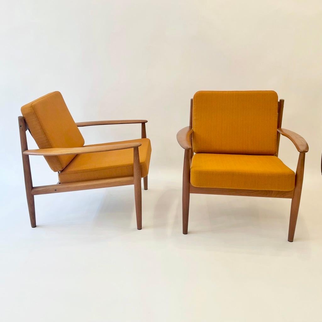 Pareja vintage de sillones de teca diseñados por Grete Jalk y fabricados por France & Son en Dinamarca hacia la década de 1950
Estado original, sin restaurar, sólo espuma nueva pero tapicería original de lana naranja. 
Bonitos detalles, reposabrazos