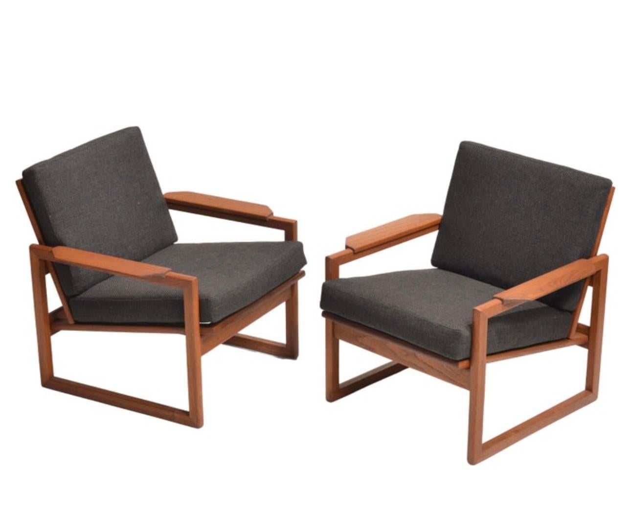 Designed by Sven Ellekaer for Komfort in Denmark, 1960’s, this sculptural pair of lounge chairs feature solid teak frames with striking open sled bases, gently sloped backs, and wide flat armrests. The design perfectly captures the Danish Modern