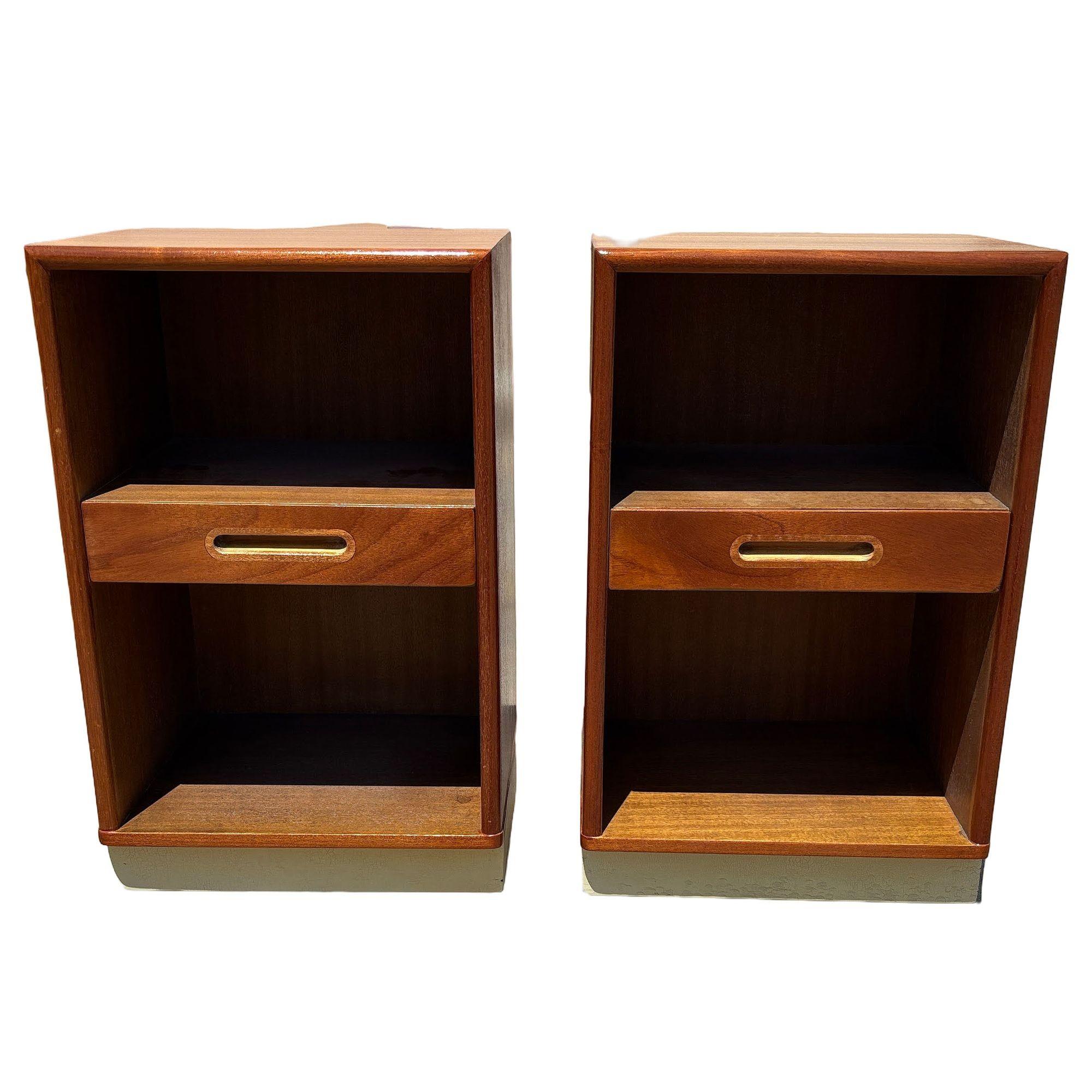 This striking pair of mid-century Minimalist teak and mahogany wood nightstands features a single drawer and cubby hole, with a sleek profile designed by Edward Wormley for the Dunbar furniture company. Featuring rich wood finishes and clean lines,