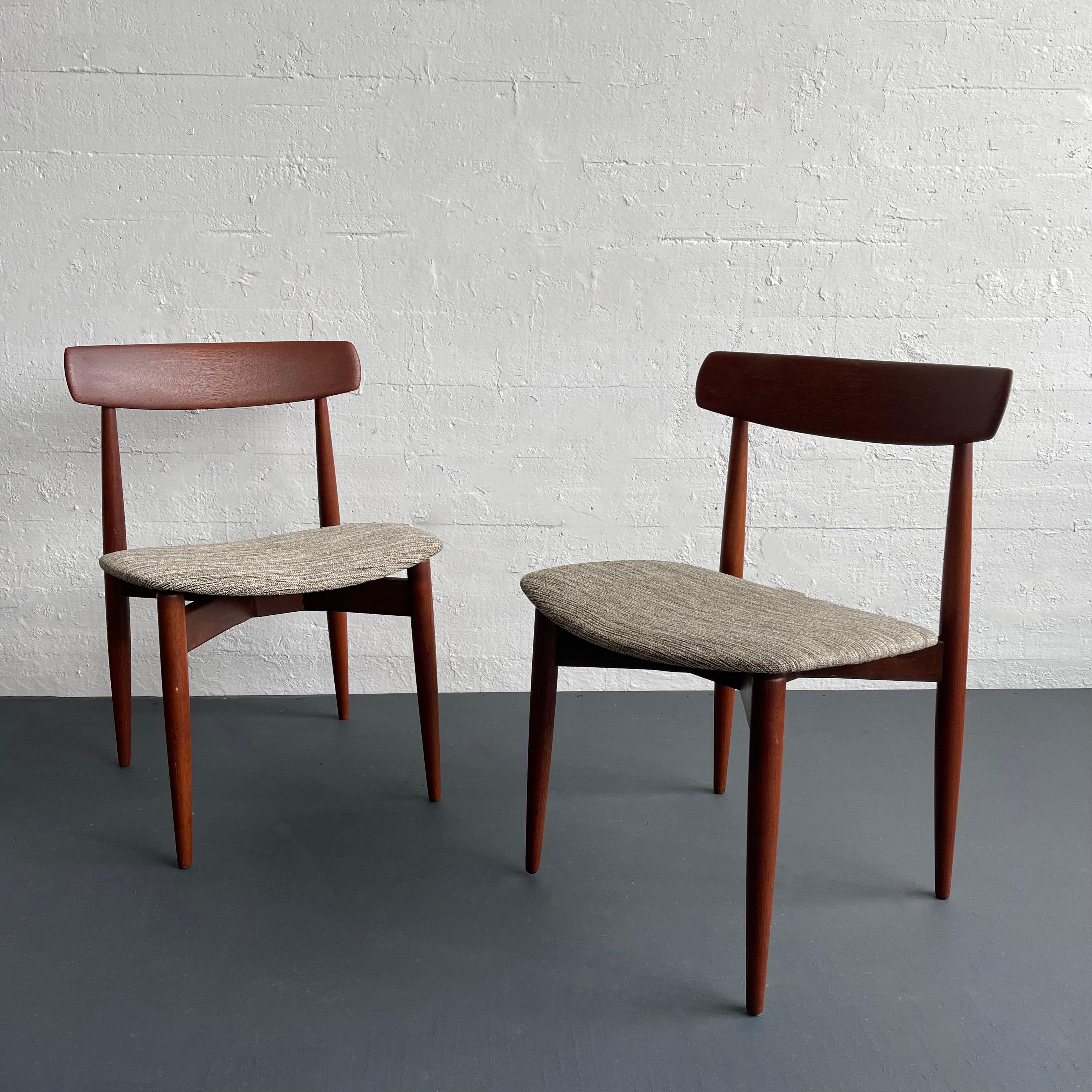 Paire de chaises de salle à manger d'une grande élégance, conçues par le designer danois H. W. Klein pour Bramin Mobler. Elles sont fabriquées en bois de teck massif et sont dotées d'un dossier incurvé, magnifiquement sculpté, et d'une assise