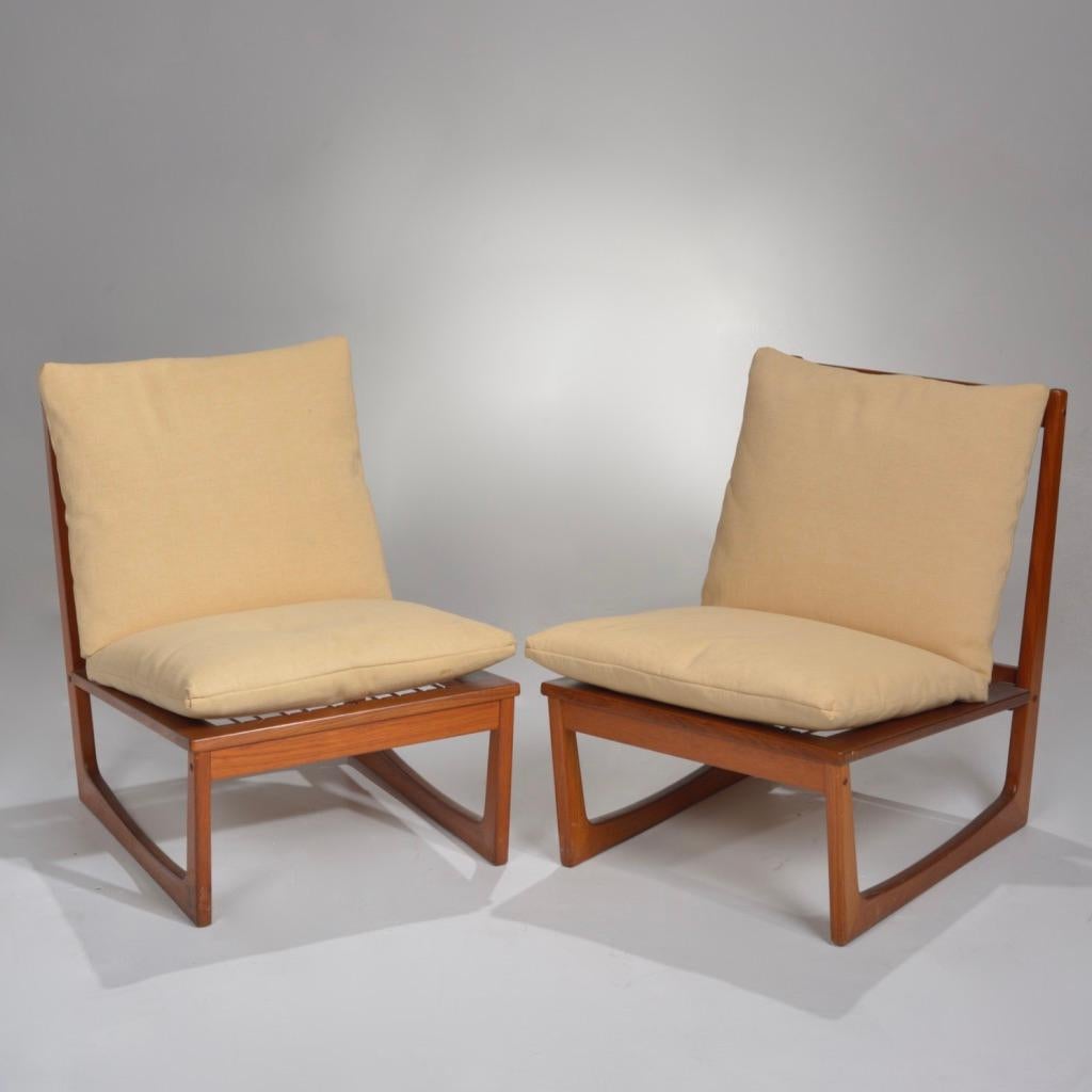 Pair of teak slipper lounge chairs by Jacob Kjaer. Featuring a beautiful slatted back, sleigh legs, and pale yellow cushions. 
 