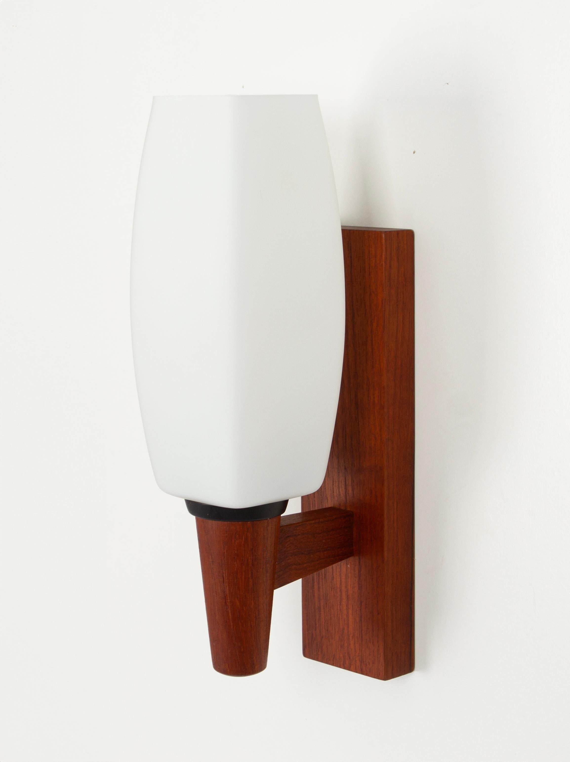 Pair of teak wall lights with opal Glasses by Kaiser Leuchten, Germany, 1960s.
Modern wall lamp in solid teak with opal glasses gives off a very cozy and diffused light.
The light sculpture impresses with clear lines and perfect craftsmanship of the