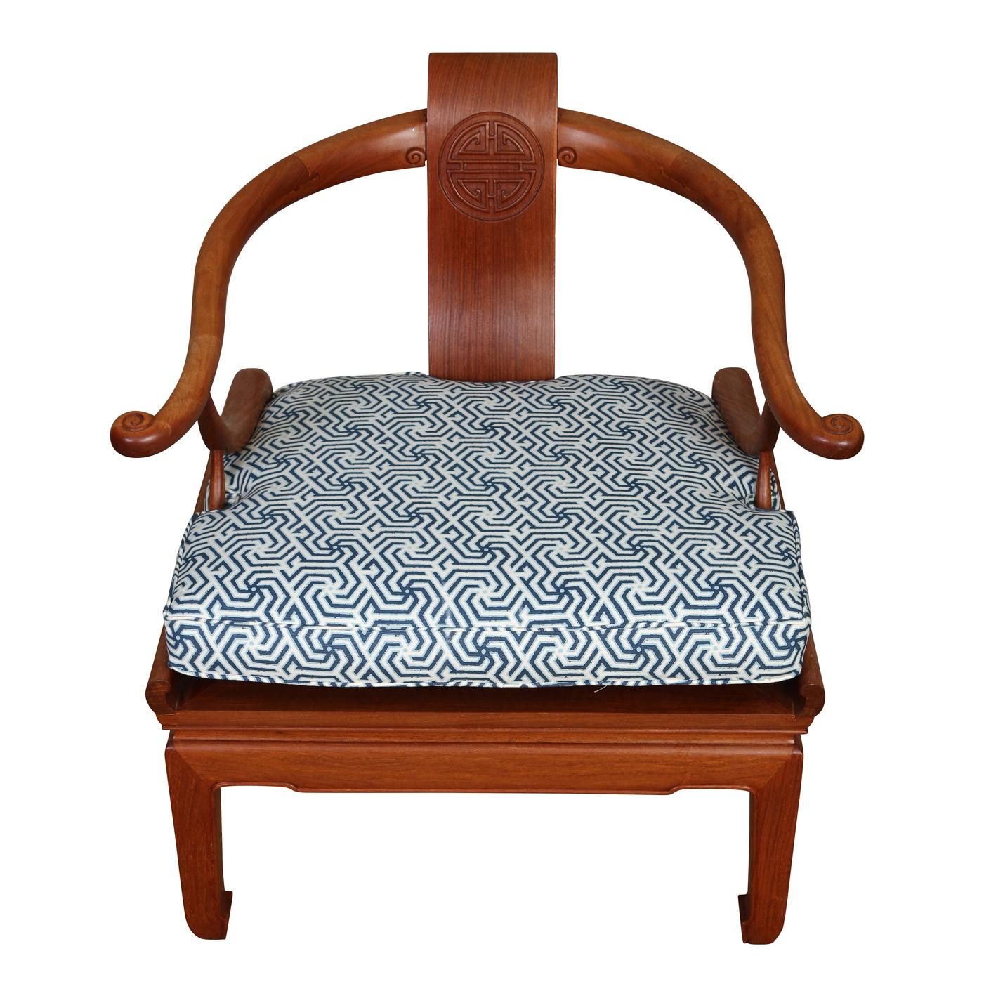 A pair of vintage teakwood Asian horseshoe arm chairs with newly upholstered geometric blue and white seat cushions and carved vertical single panel back.
