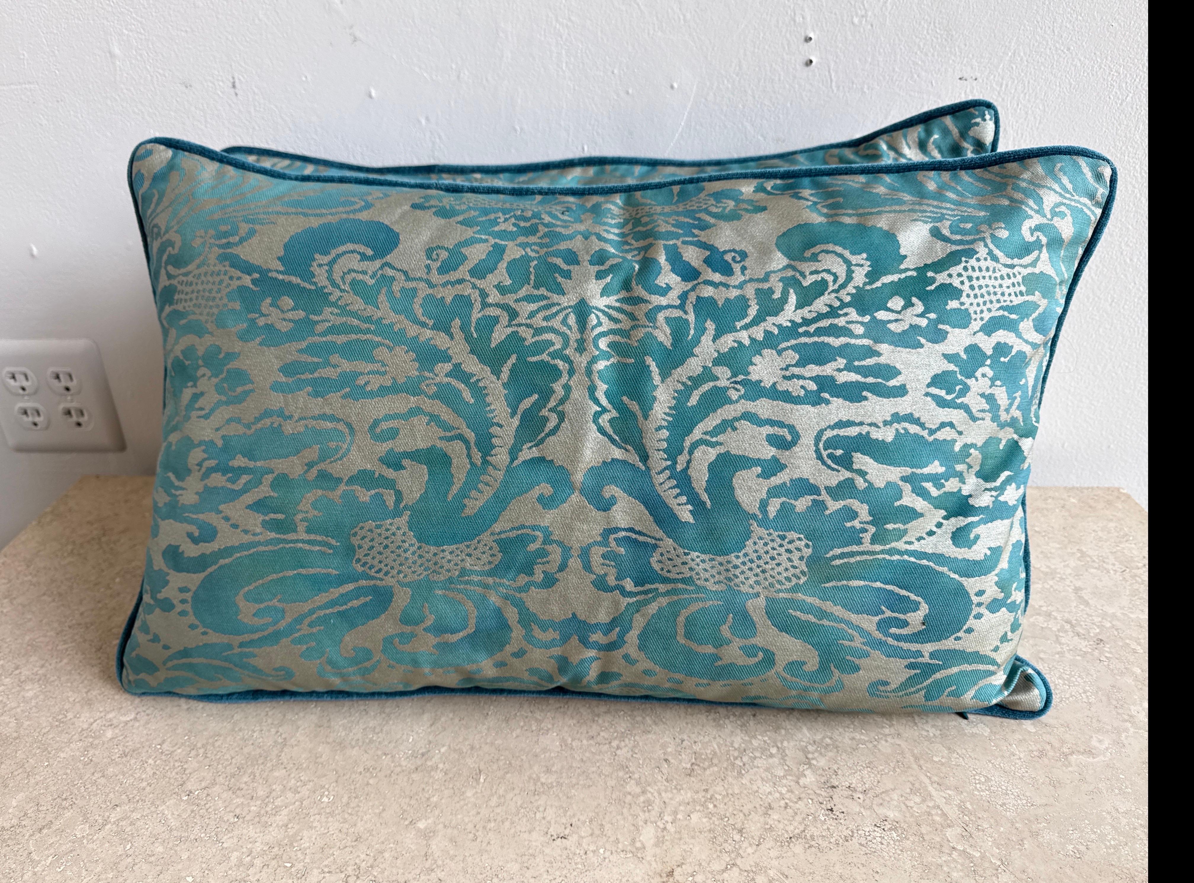 Este elegante par de almohadas presenta auténticos frentes textiles Fortuny en un rico estampado de damasco verde azulado y dorado plateado, mostrando el lujoso y consagrado diseño veneciano por el que Fortuny es célebre. El dibujo es intrincado y