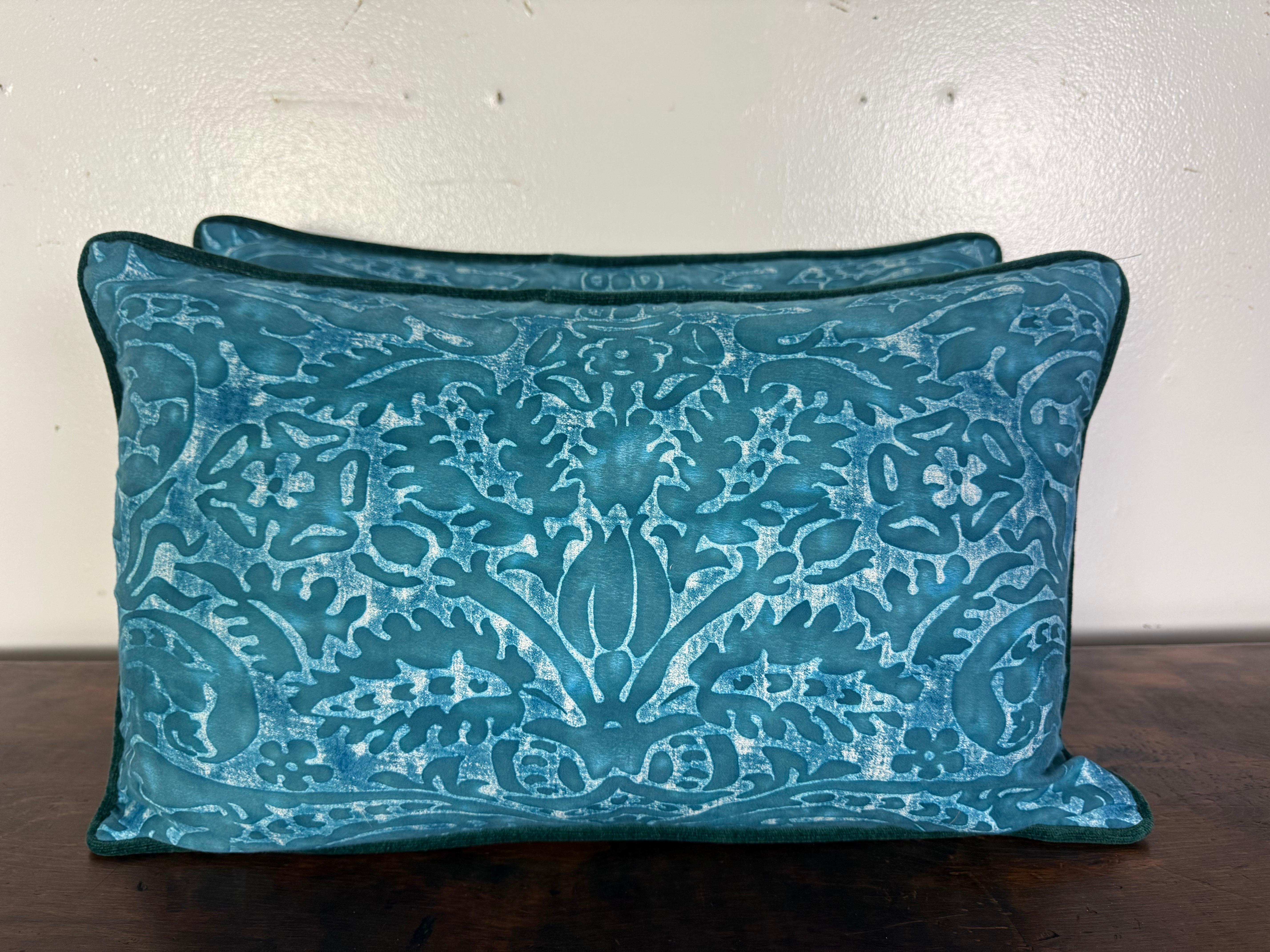 Este elegante par de almohadas muestra un lujoso diseño en un intenso tono azul turquesa. La parte delantera presenta un motivo botánico y floral con una textura suave, casi lavada con el tiempo, que da profundidad y dimensión al dibujo. El