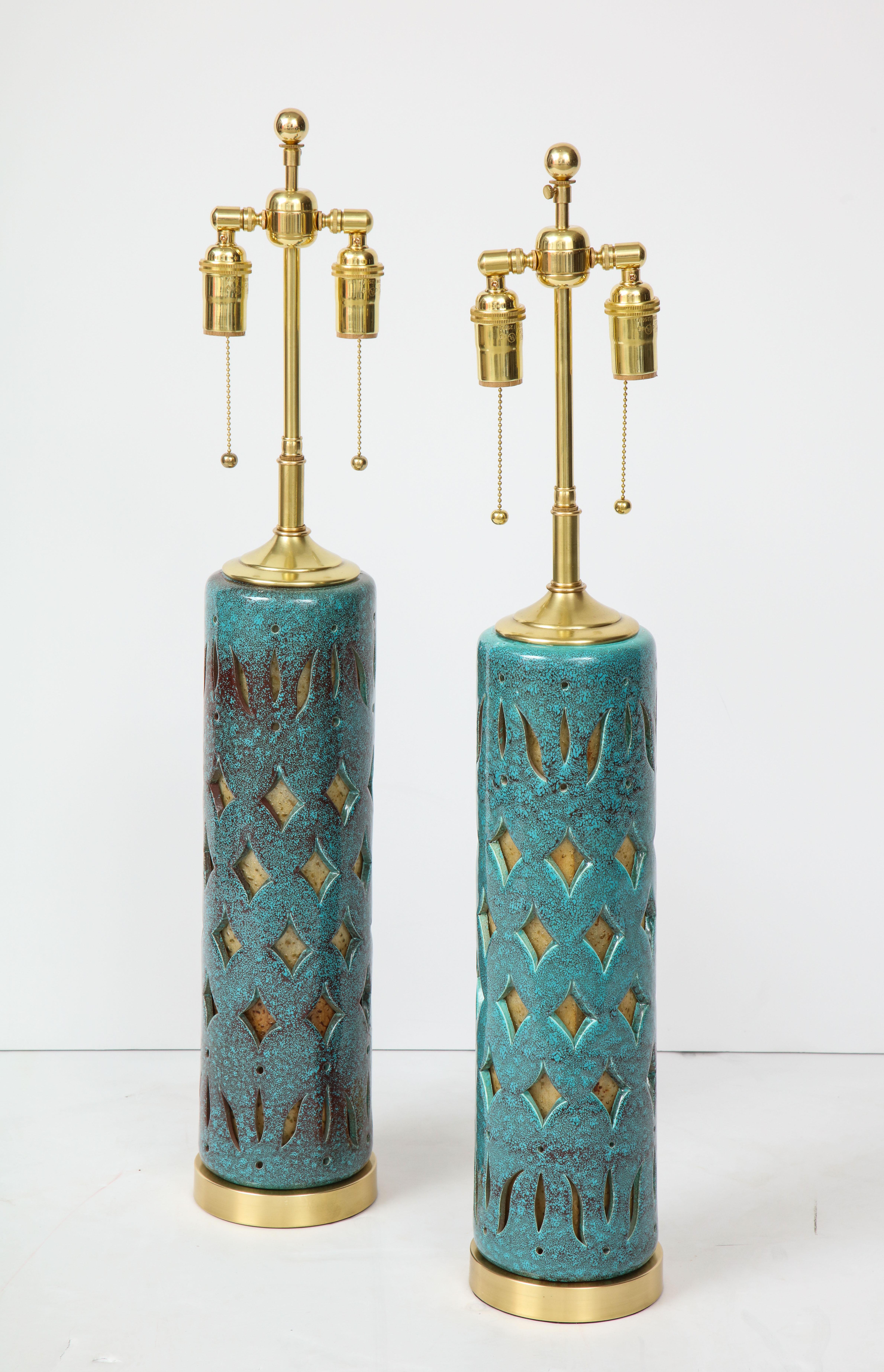 Pair of 1960s Italian ceramic lamps with a pierced cut out design and
a beautiful teal glazed finish.
The lamps have been newly rewired with polished brass double clusters.