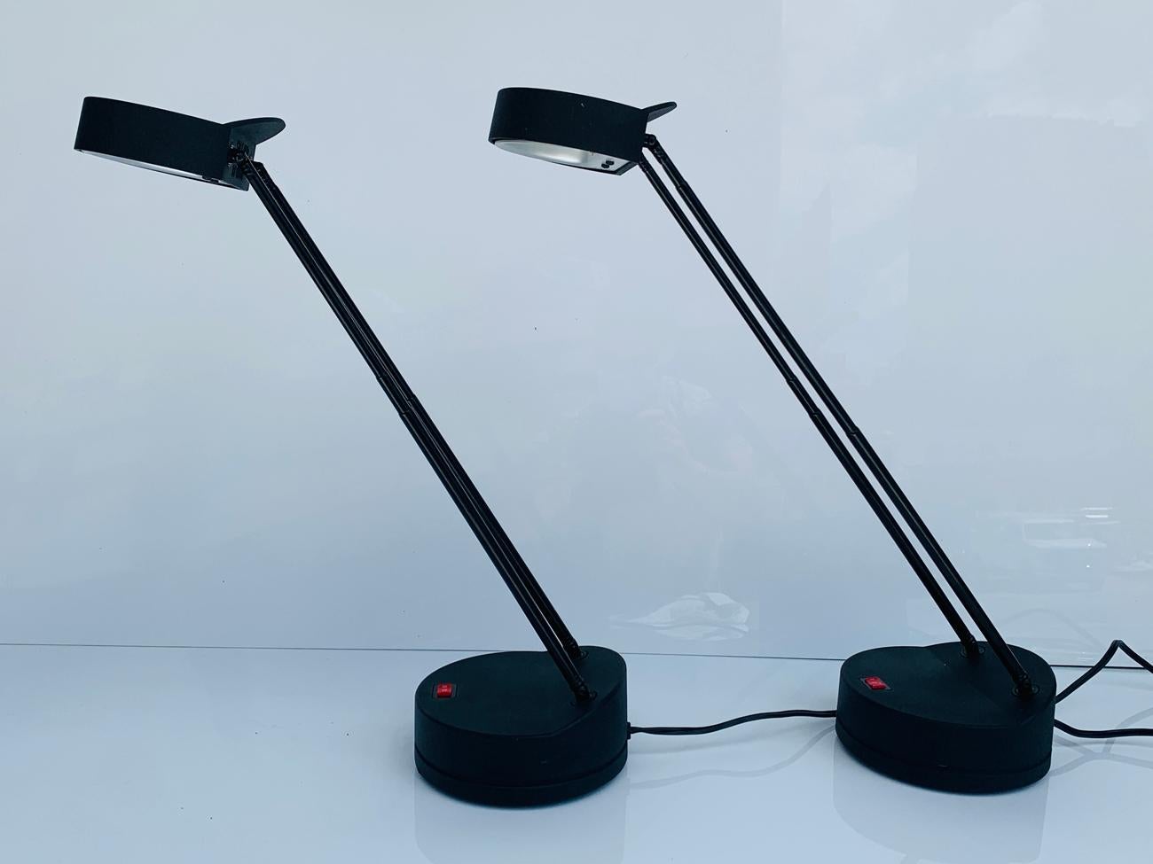 Beautiful and modern pair of telescoping and height adjustable table/reading lamps designed and manufactured in Italy by Stephano Cevoli and manufactured by Vermezzo as part of the Spoiler collection.

These lamps feature a round base and a double
