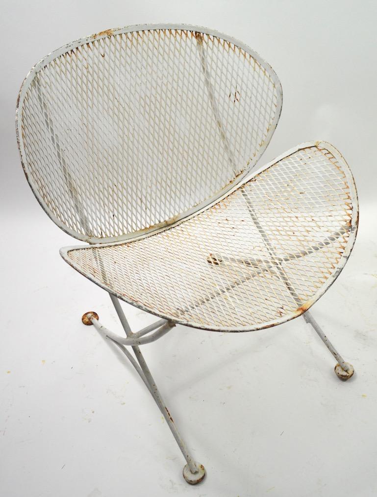Pair of Clamshell chairs designed by Maurizio Tempestini for Salterini. Both chairs show significant cosmetic wear to the paint finish, both are structurally sound and free of repairs. Wrought iron rod frames with metal mesh seat and back. Designed