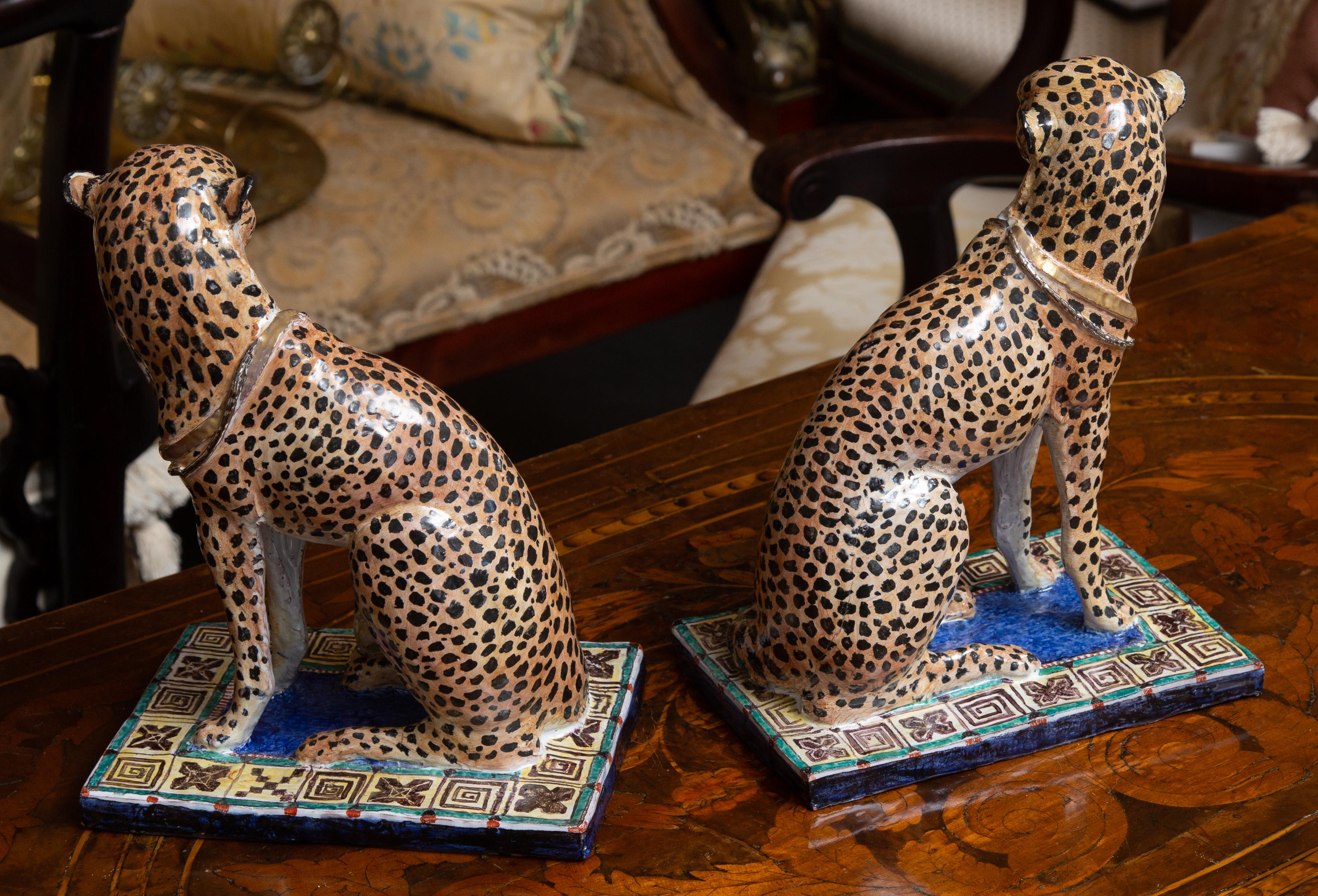 This is a beautifully crafted pair of mirror-image hand-painted terracotta cheetahs, situated on a colorful base, 20th century.
