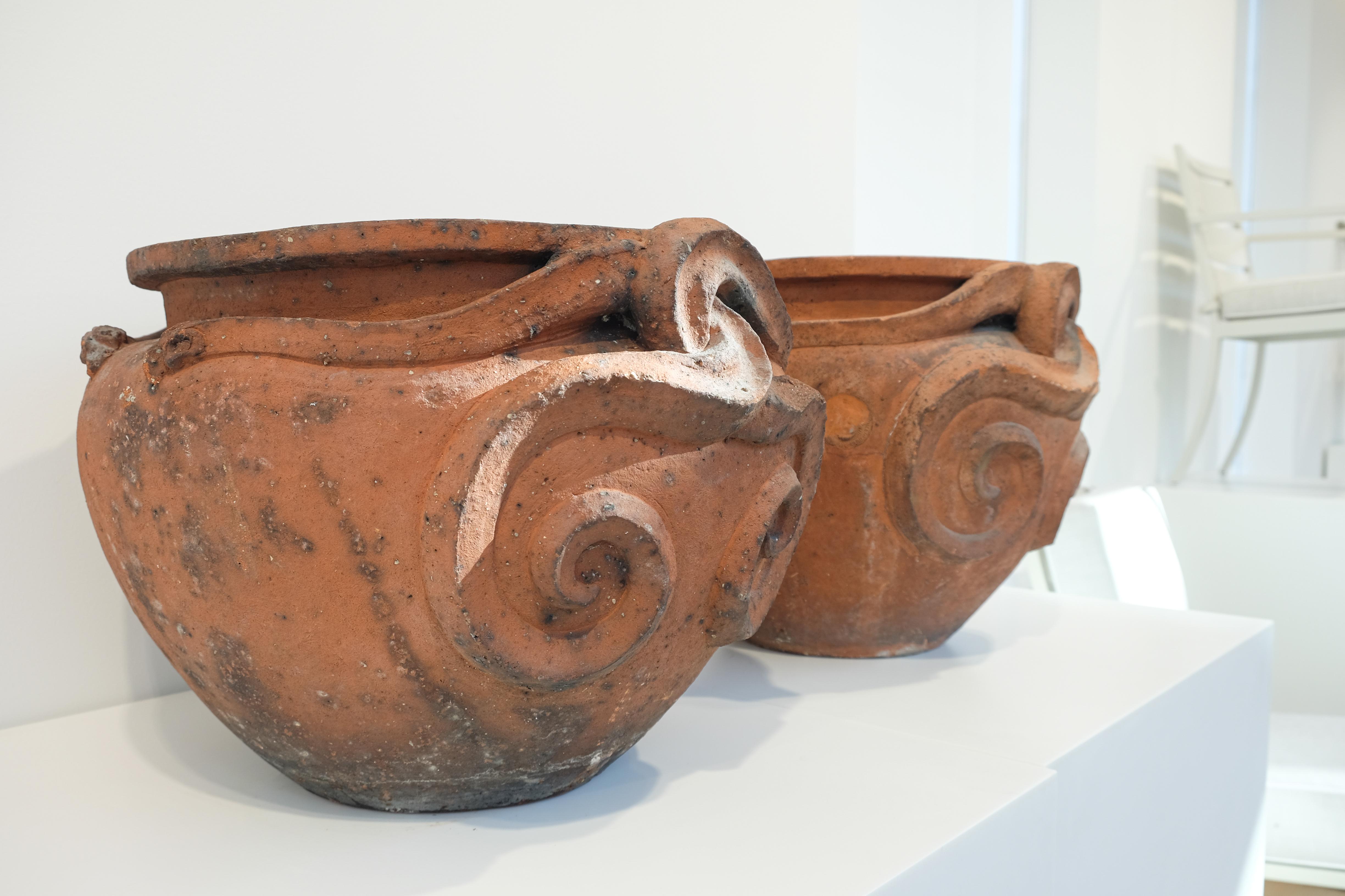A pair of 19th century Compton Pottery terracotta pots with serpent decoration. With original Compton Pottery stamp registration number signifying Compton Potter’s Art Guild. The snake pots were designed by Mary Setton Watts, the founder of the