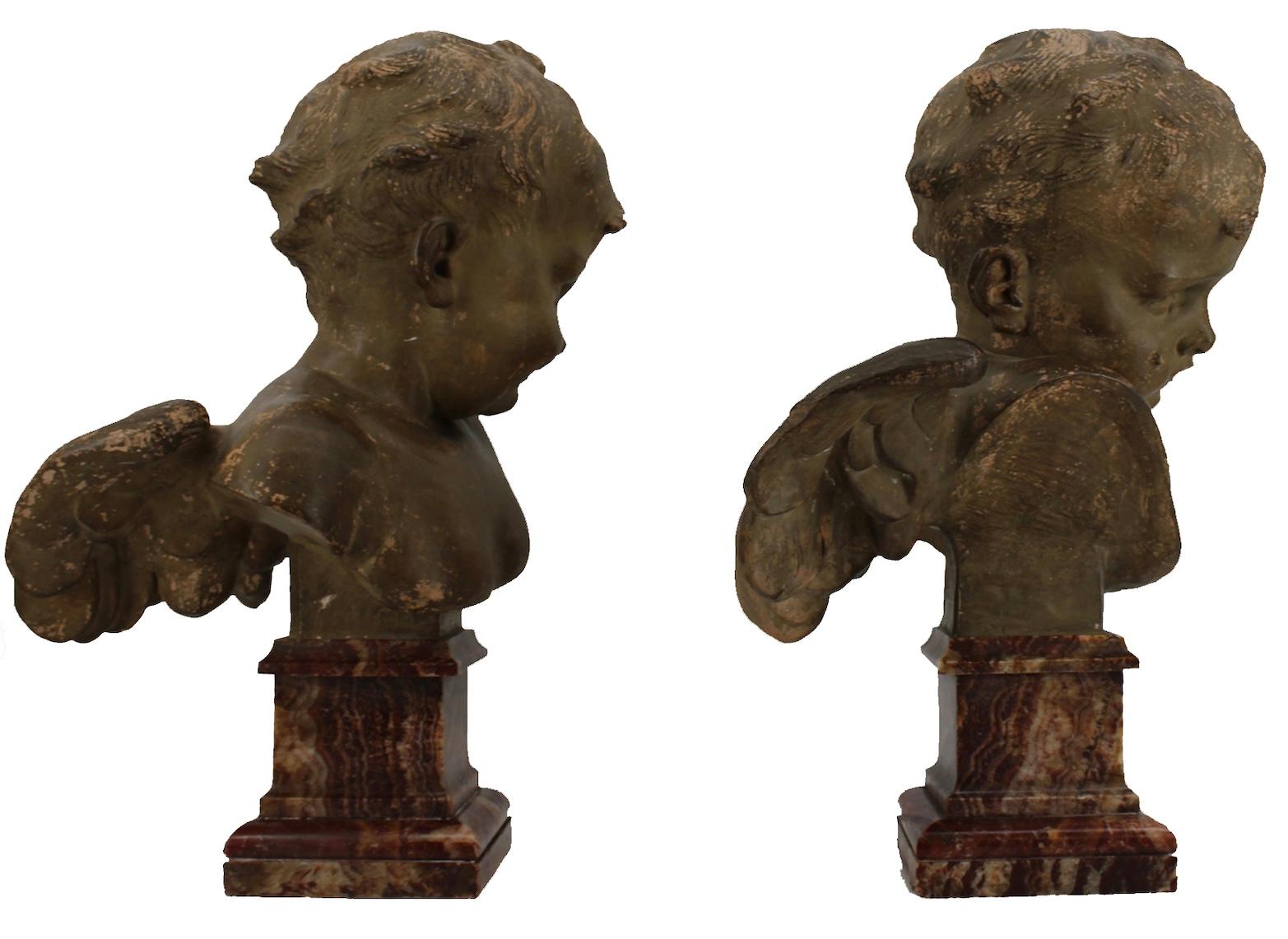 A large pair of terracotta winged busts of angels on marble bases. Signed 