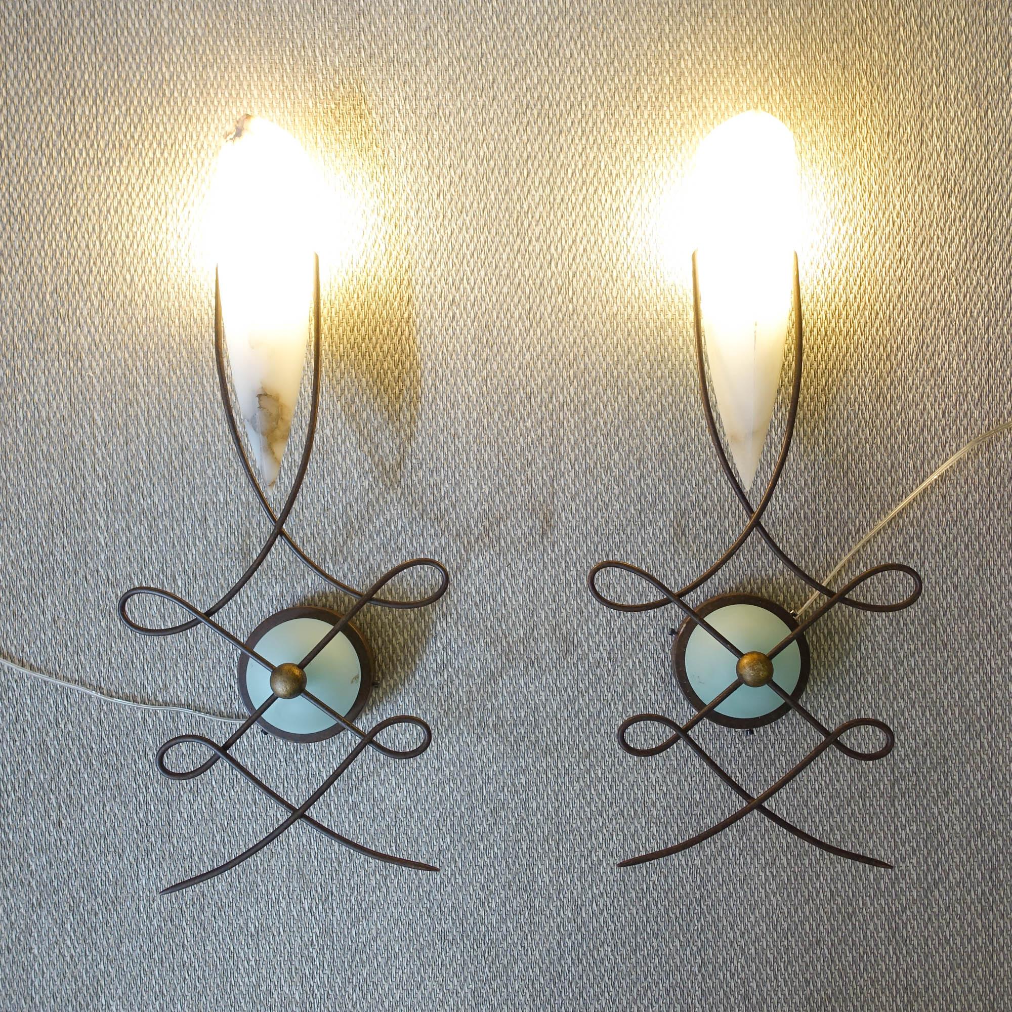 This pair of wall lamps, model Louvre, was designed by Jean-François Crochet for Terzani, in Italy, during the 1980's. These lamps are made of handcrafted metal with a rust finish and a finely crafted cream-colored alabaster shade. The thick