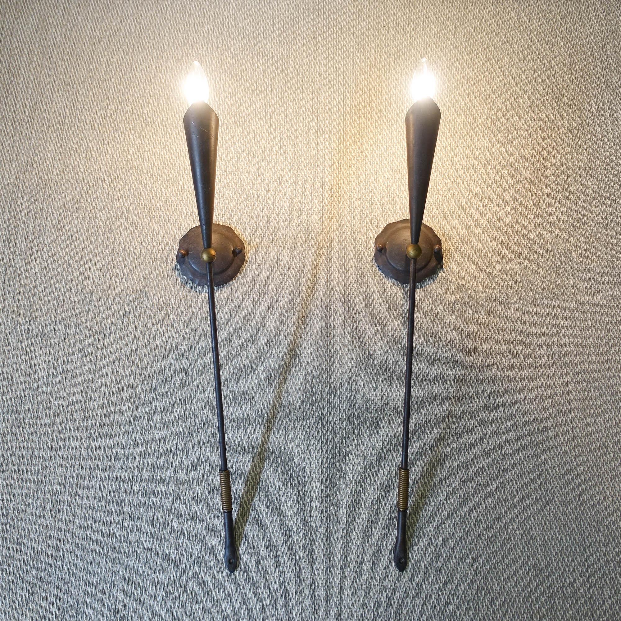 This pair of wall lamps, was designed by Jean-François Crochet for Terzani, in Italy, during the 1980's. These lamps are made of handcrafted metal with a rust finish and gold details. The design is reminiscent to medieval torches.
It fits a E14