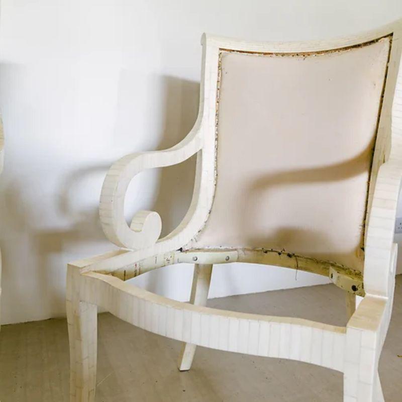 A pair of un-upholstered tessellated bone veneered carver dining chairs with scrolling arms and sabre legs, designed by Enrique Garcel for Karl Springer, 1970s

Additional Information:
Material: Bone
Dimensions: 53.5 D x 58.5 W x 100 H cm.