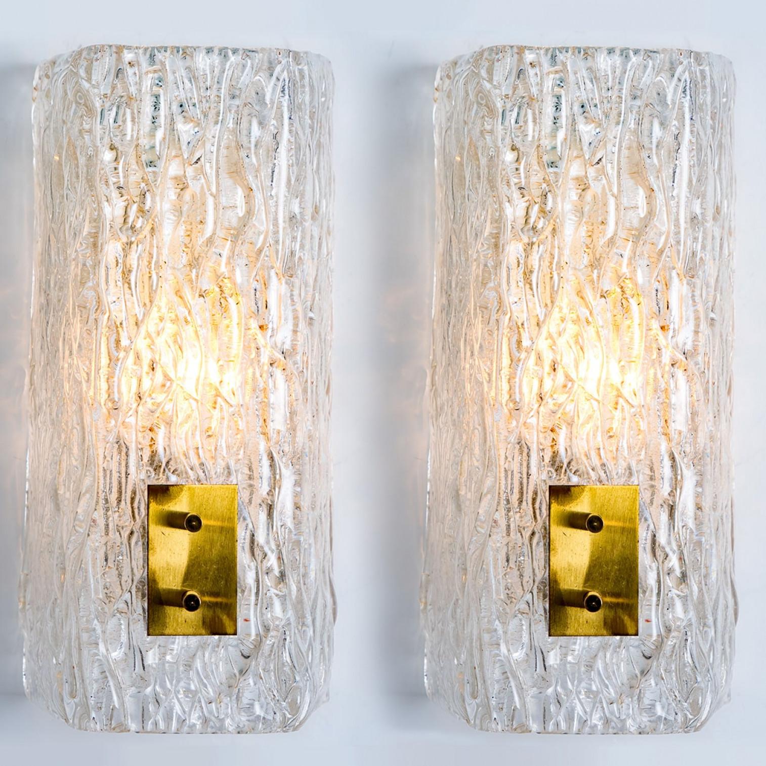 1 of the 2 high-end wall sconces made of textured clear glass on a brass hardware. Designed and produced by J.T. Kalmar, Austria in the 1960s. Minimalistic design executed with a taste for excellence in craftsmanship. These are real statement
