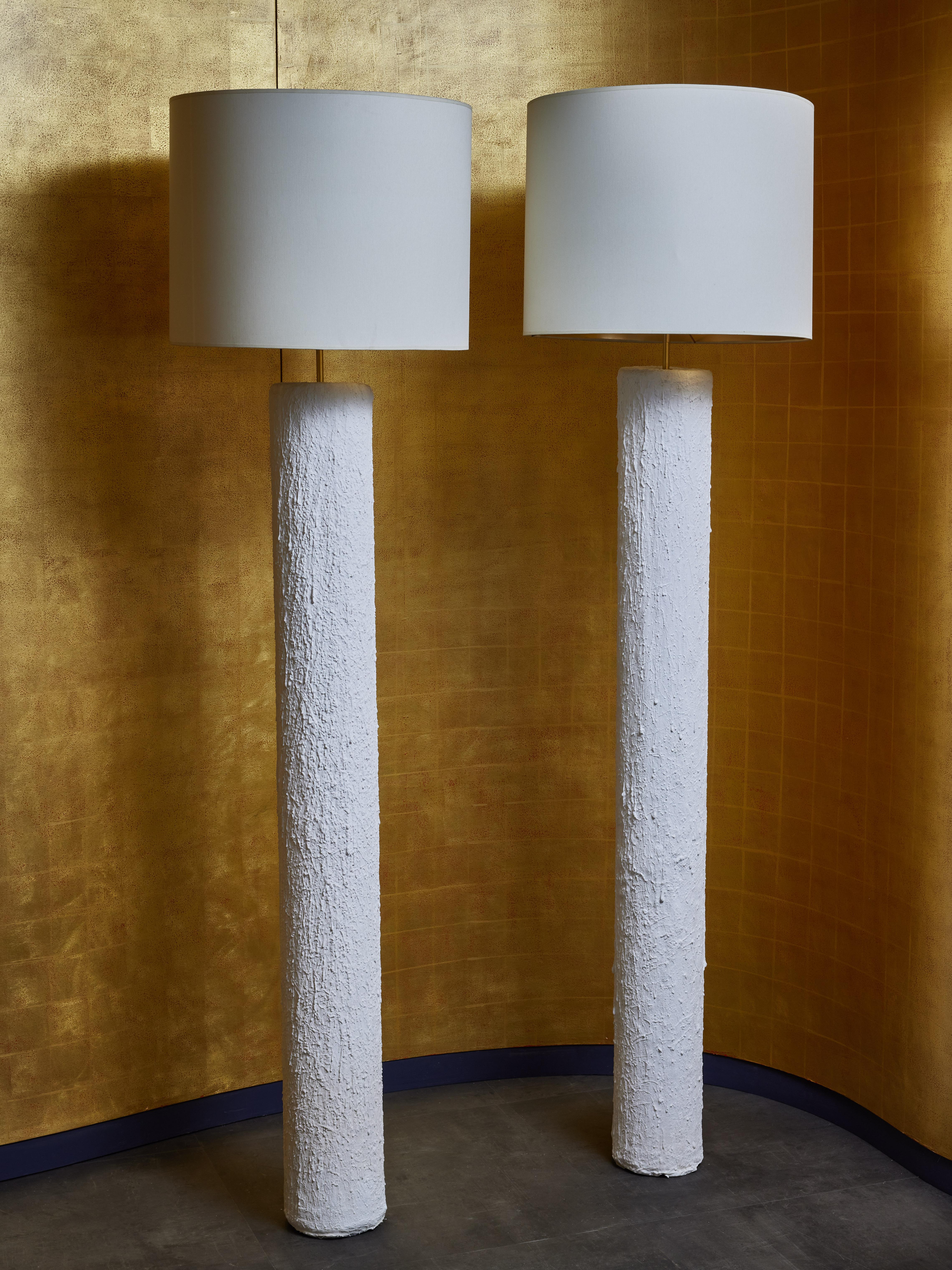Pair of cylindrical floor lamps, made of steel covered in textured plaster.