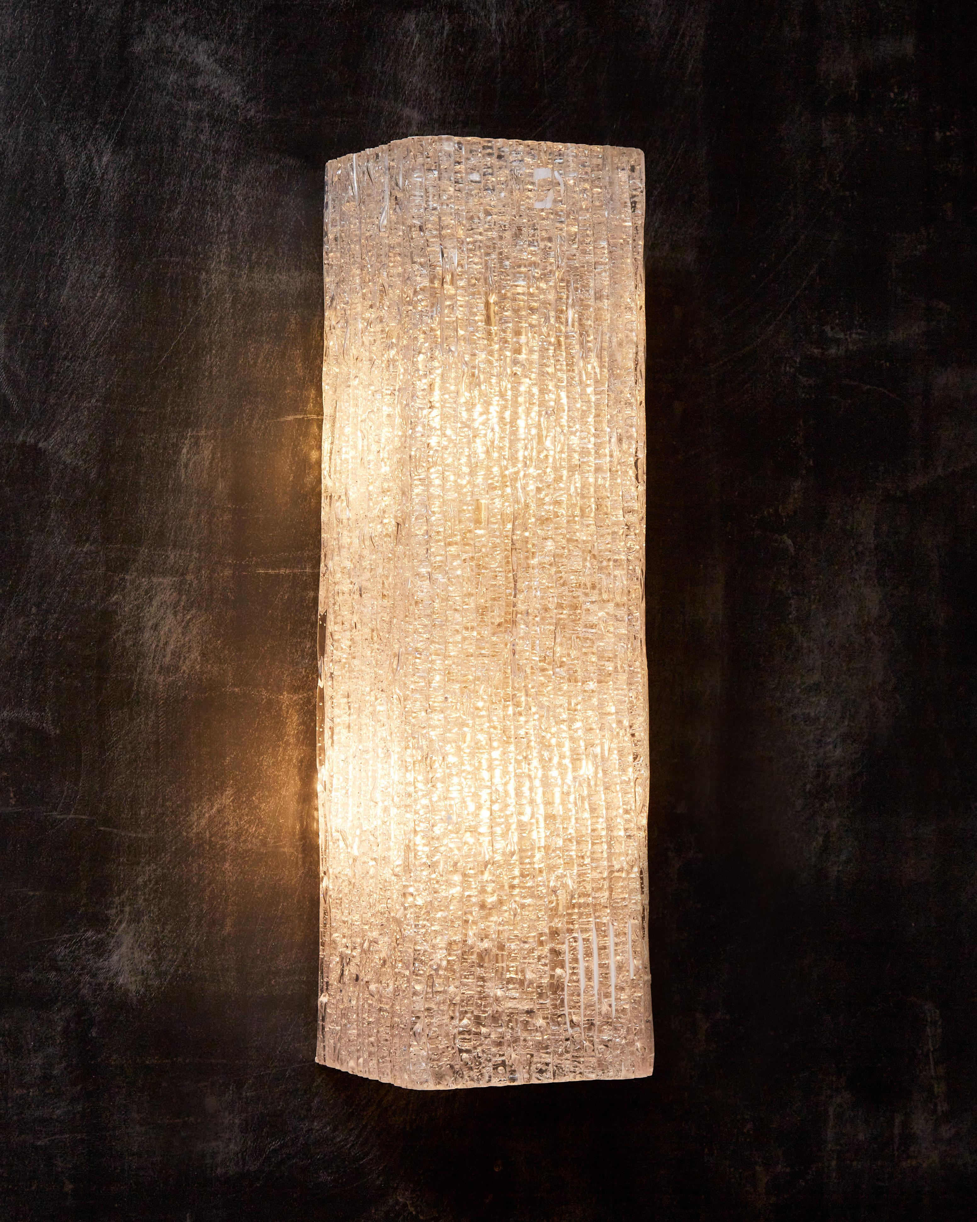 Pair of vintage wall sconces made of a folded sheet of textured plexiglass, hiding a metal structure with two lights.