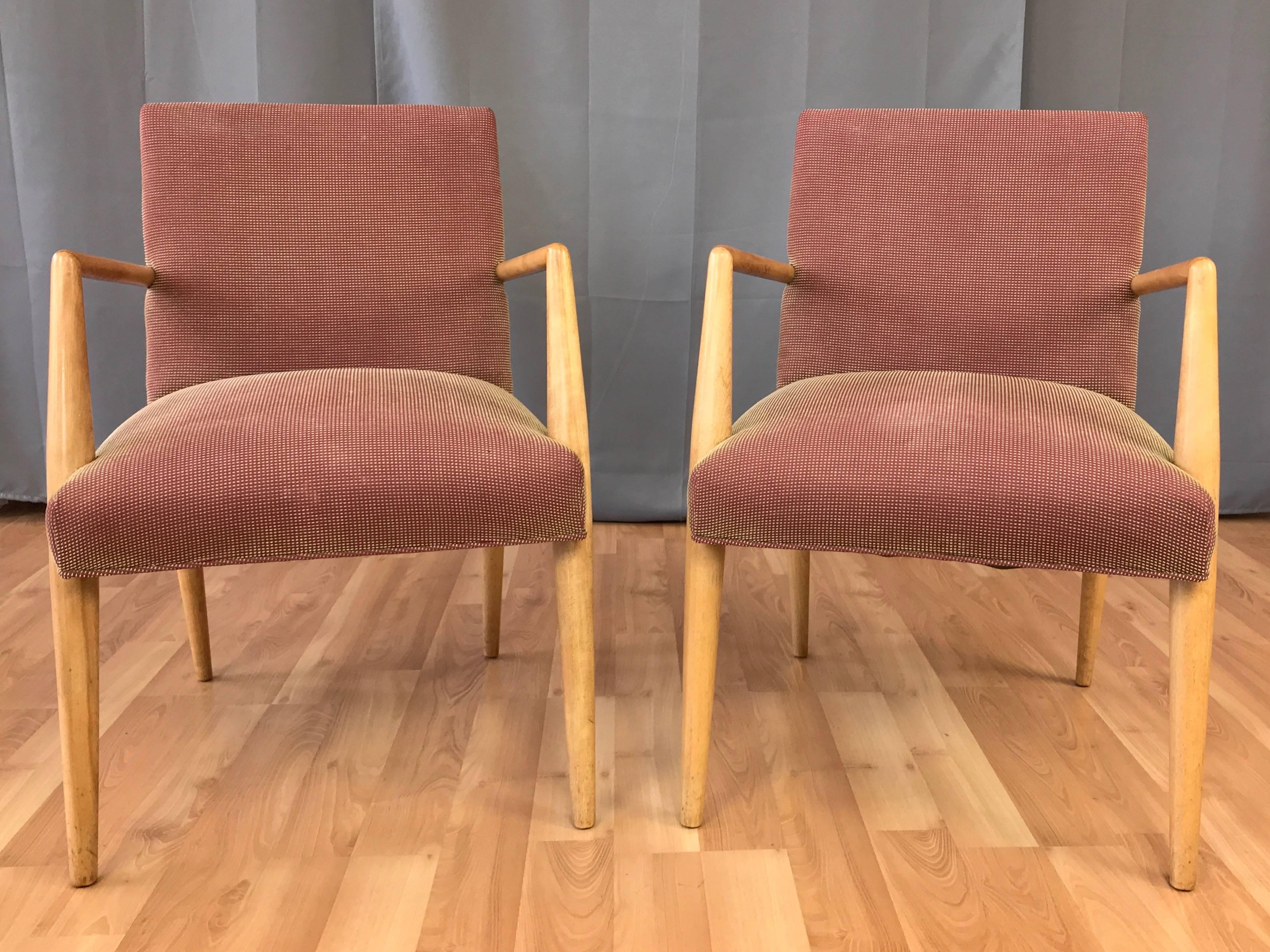 A pair of circa 1952 model No. 1686 maple dining or lounge chairs with arms by T.H. Robsjohn-Gibbings for Widdicomb Furniture Co.

Smoothly tapered front legs transition nicely into angled arms, creating a clean and Classic Mid-Century Modern