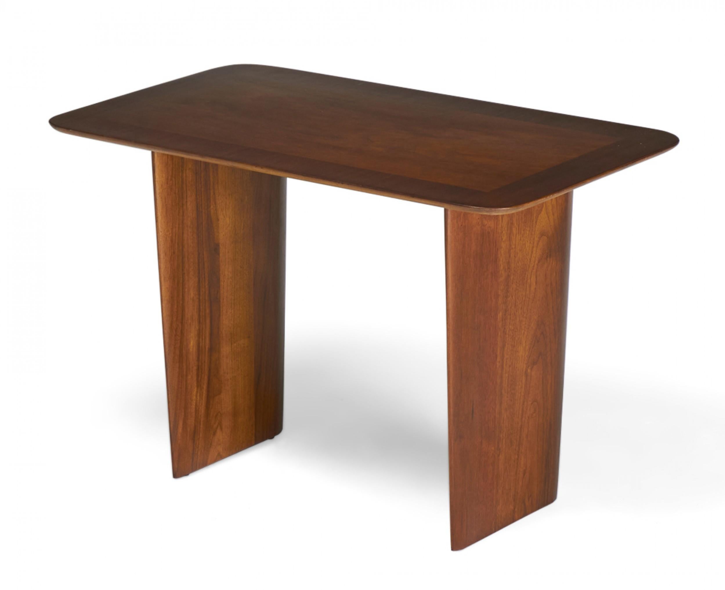 American Mid-Century (circa 1955) walnut occasional / end tables with rectangular tops with rounded corners supported by two wide solid wood legs. (T.H. ROBSJOHN-GIBBINGS FOR WIDDICOMB FURNITURE)(PRICED AS PAIR)

