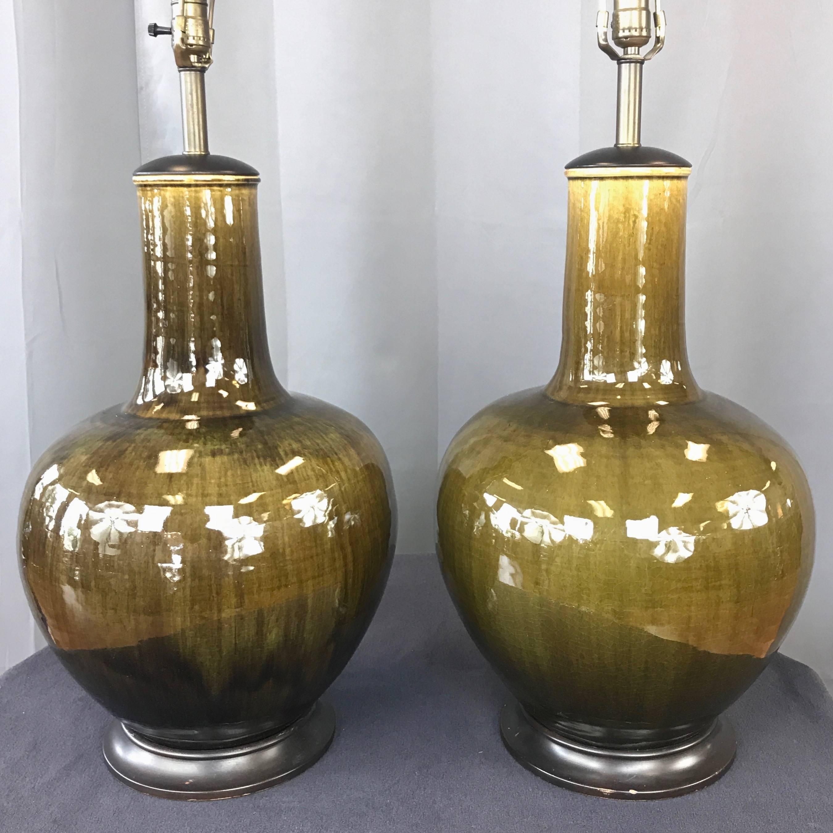Une paire très impressionnante de lampes de table monumentales en céramique émaillée verte du milieu du siècle dernier par Thai Celadon Company. 

Forme asiatique classique avec un corps en forme de pot d'épices et un cou haut et robuste. Fini dans