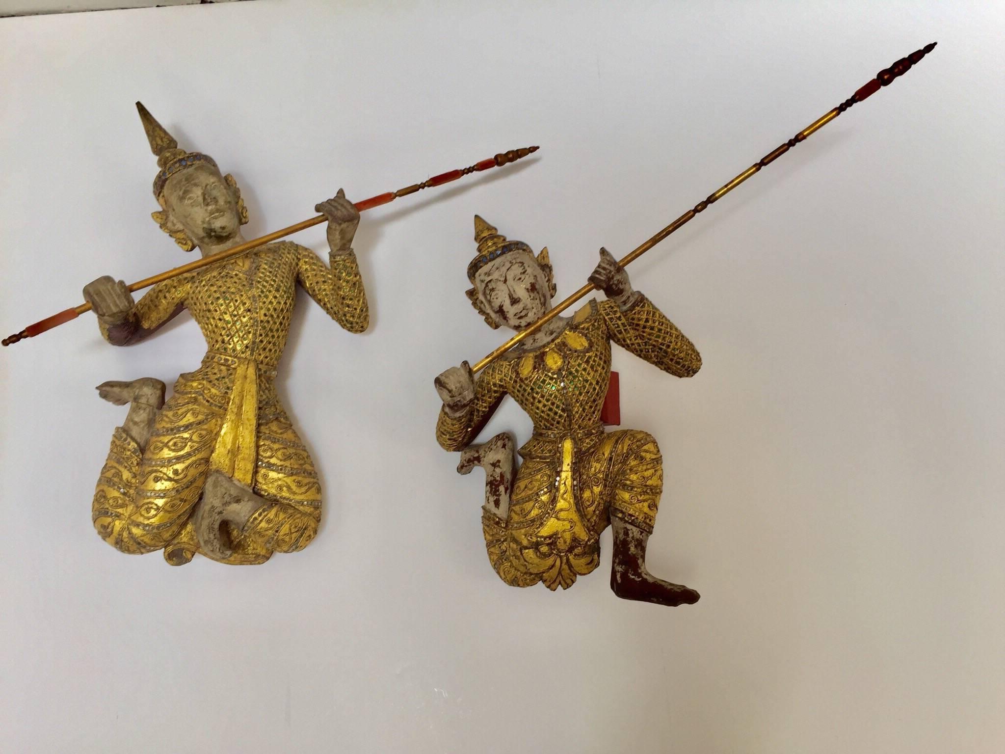 Large pair of Asian figures of Siamese dancers gilt wood sculpture, nicely carved.
Thai figure sculpture in seated position holding a spear, gilt over red lacquer that can be seen in the back.
Gold gilt adorned with green and clear mirrored gem