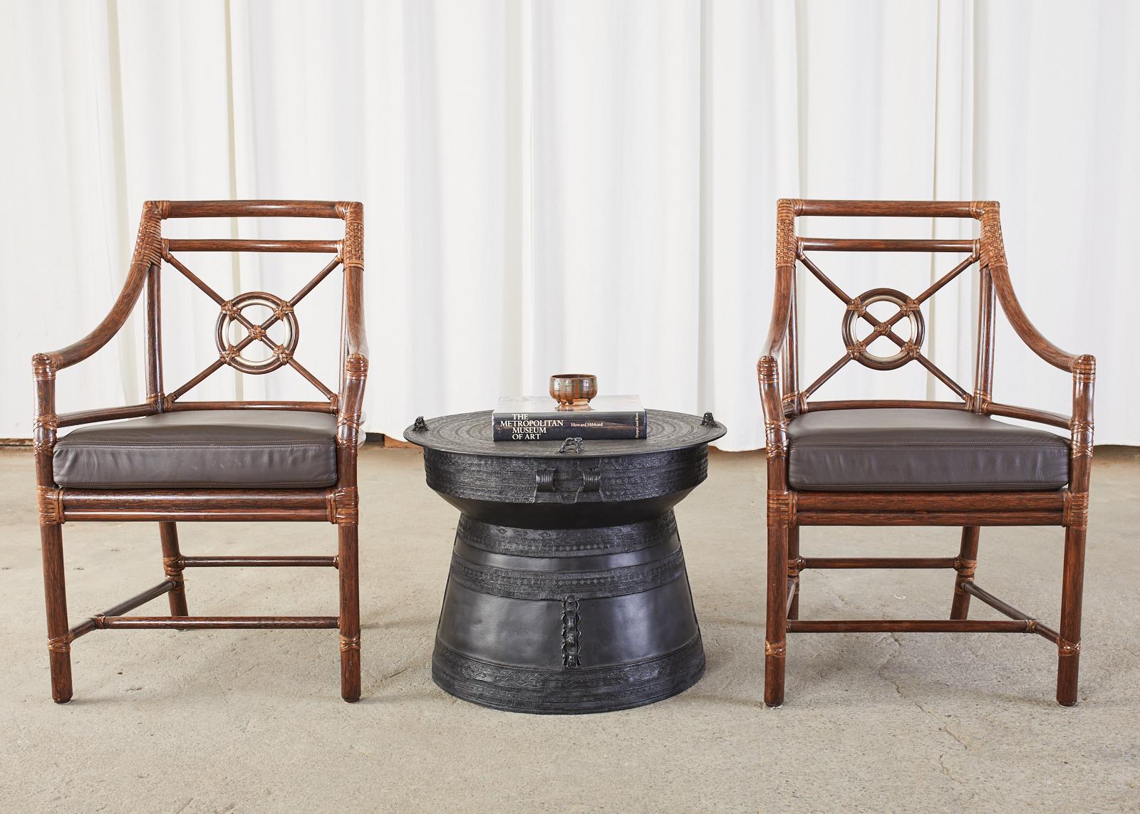 Large pair of Thai frog drums or rain drums featuring an ebonized metal finish. These drink side tables measures 24.5 inches across constructed from cast metal in a waisted form decorated with intricate geometric bands around the body and concentric