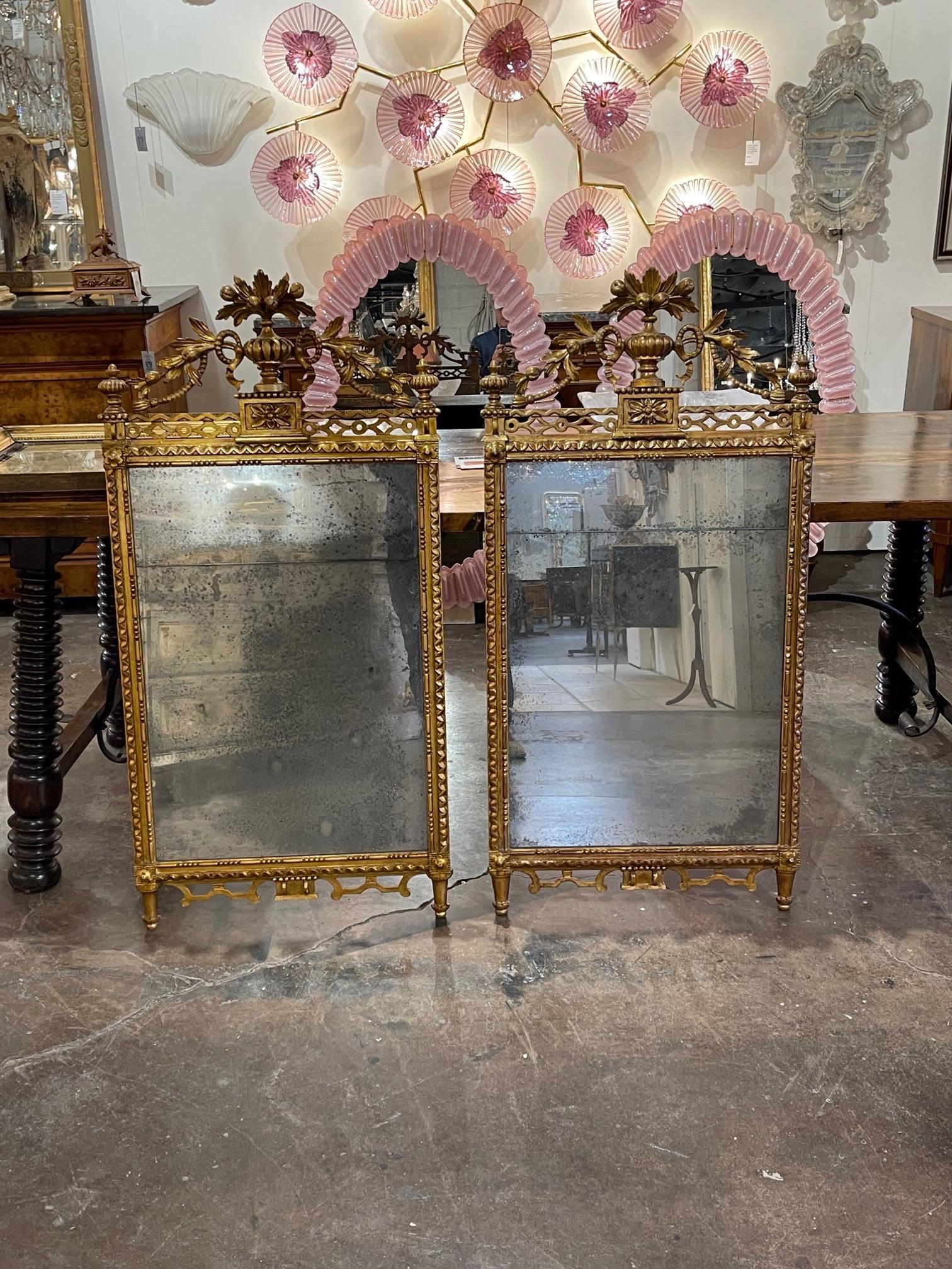Gorgeous pair of the 19th century carved giltwood mirrors. Elaborate carvings of an urn with overflowing flowers. These mirrors are truly exceptional!