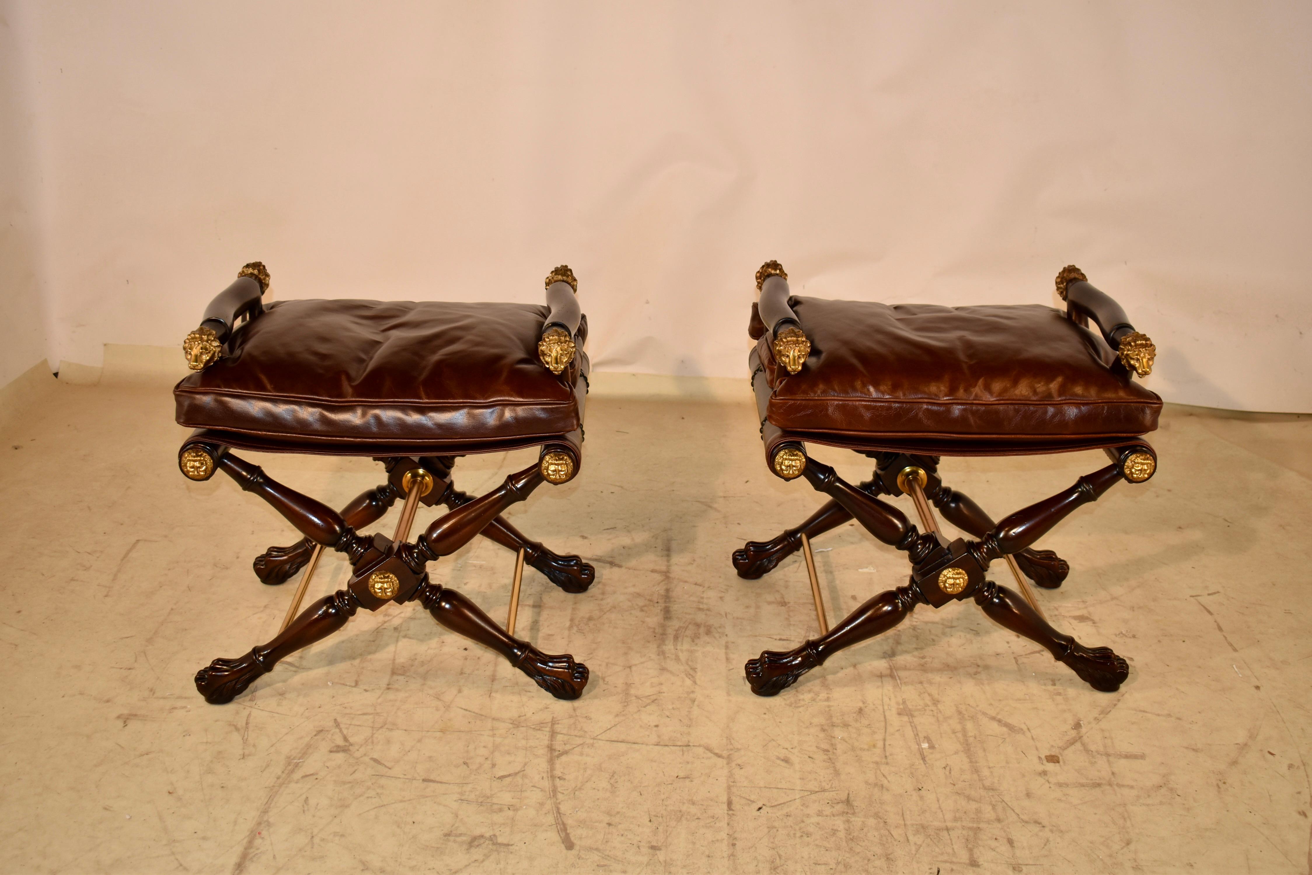 A sable mahogany and brass mounted stool in the manner of Thomas Hope, with slung seat, with lion head arm terminals, on a turned ‘X’ base. 
The look of original Regency period furniture.
Upholstered in Old English Leather.
Vintage Nail trim.