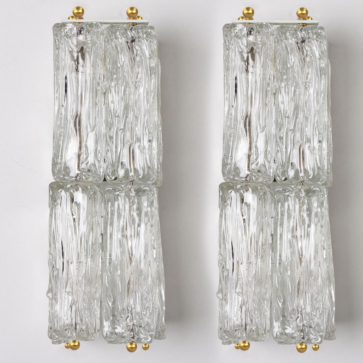 Pair of wall light fixtures by J.T. Kalmar, Vienna, Austria, manufactured in circa 1960. The glass shows a beautiful ice-like texture, which gives a diffuse light effect and a nice pattern on the ceiling and wall. It looks like the light is divided