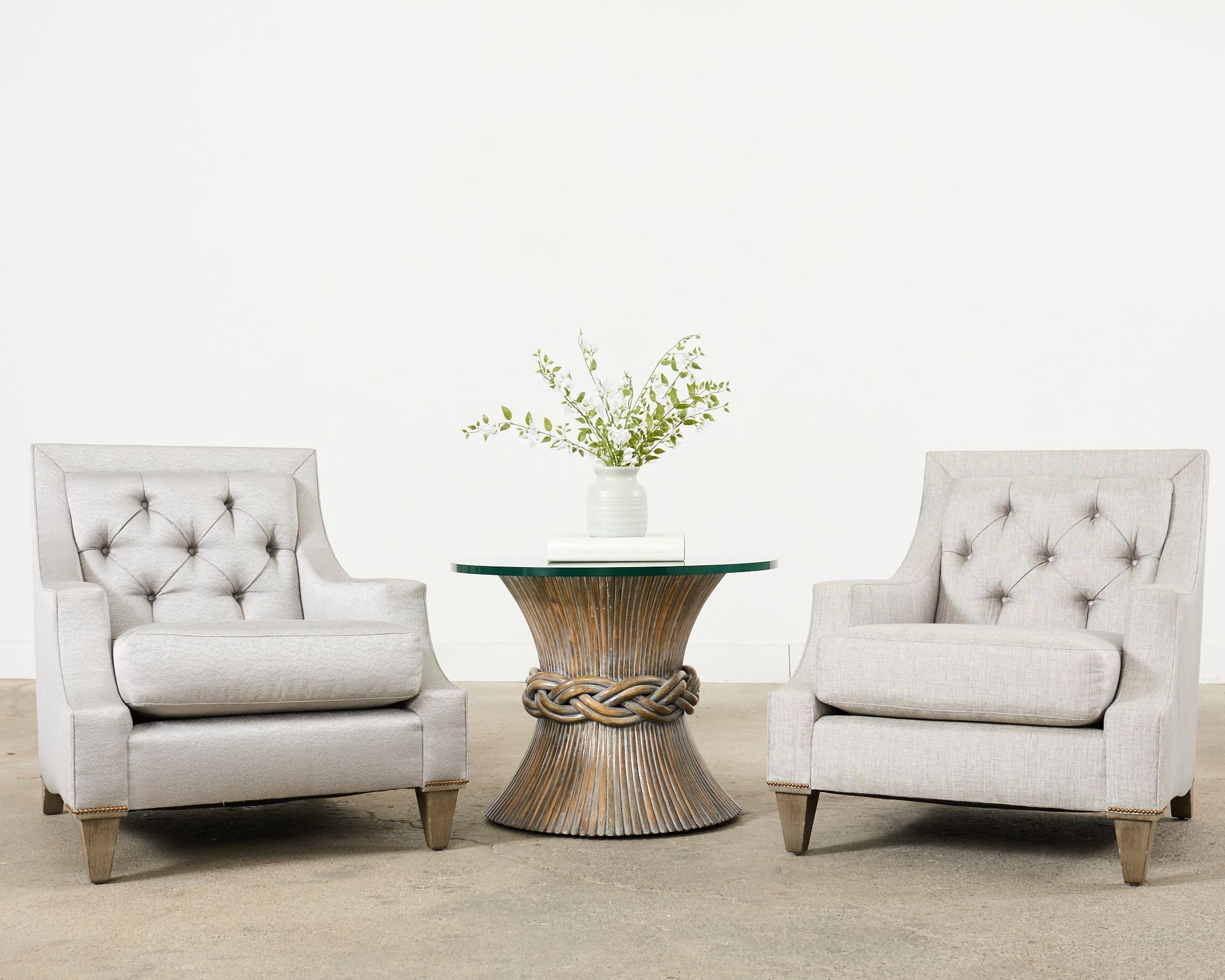 Hollywood modern pair of large max club chairs or lounge chairs designed by Thomas Pheasant for Baker. The chairs feature a large hardwood frame with slightly different but complementary shimmery grey fabric upholstery. One chair has a polished grey