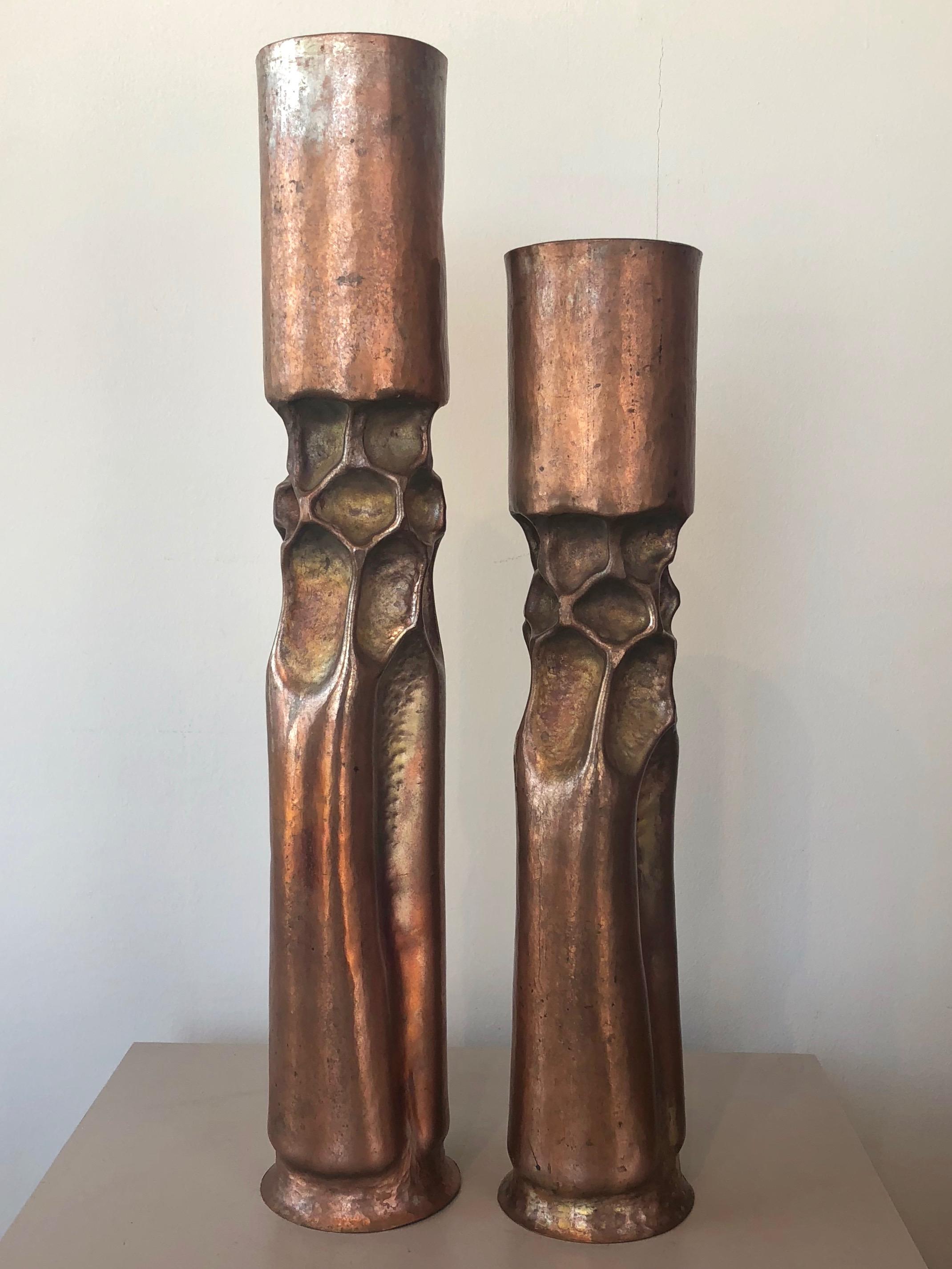 An early pair of large 1970s Brutalist copper candleholders by master metalsmith and sculptor Thomas Roy Markusen.

Tall, tortured form of hammered and shaped copper has an organic yet alien aesthetic. Artistically applied heat oxidized patina