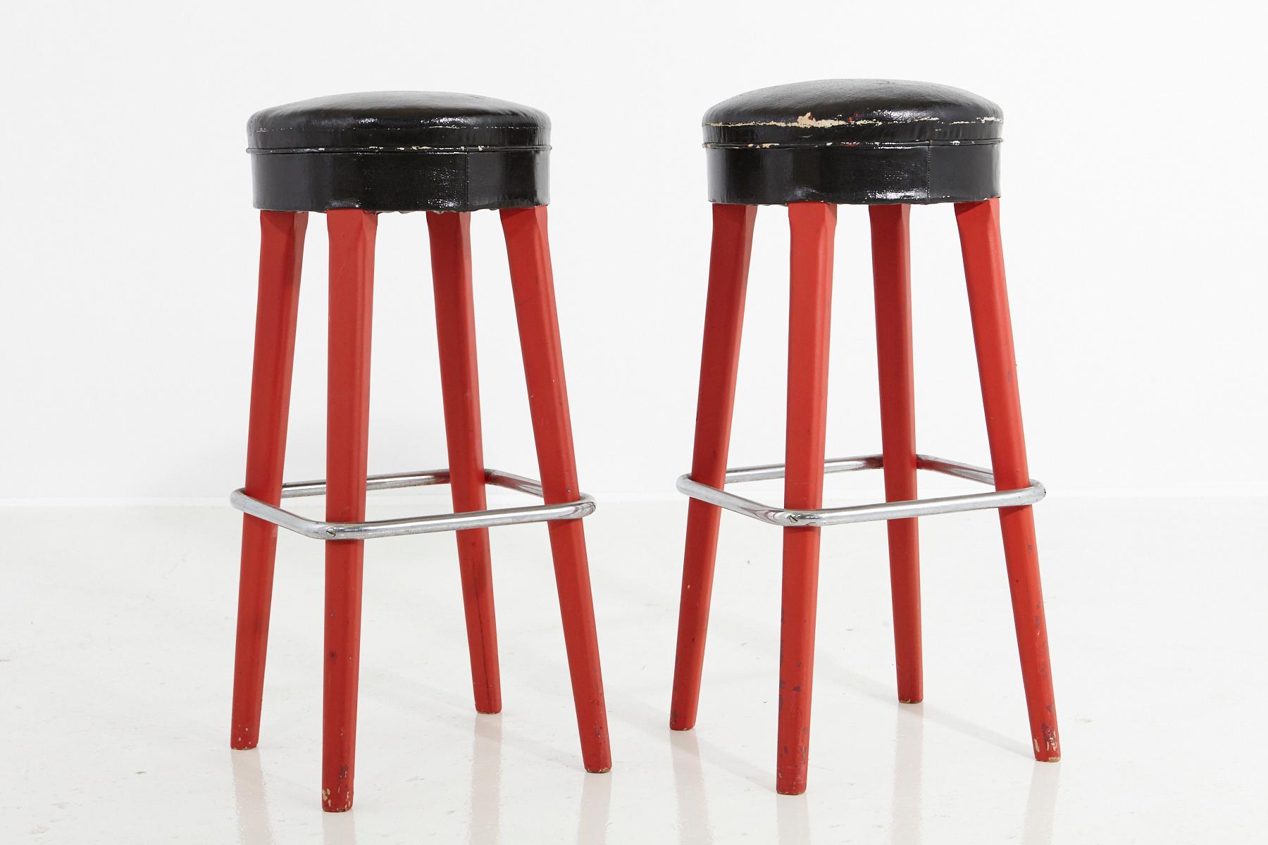 An authentic pair of Thonet stools from the 1930s, marked on the underside with Thonet Logo and certificate.
Red painted wooden base with chrome foot support and black faux leather seats.
The red paint is not original and probably has been added