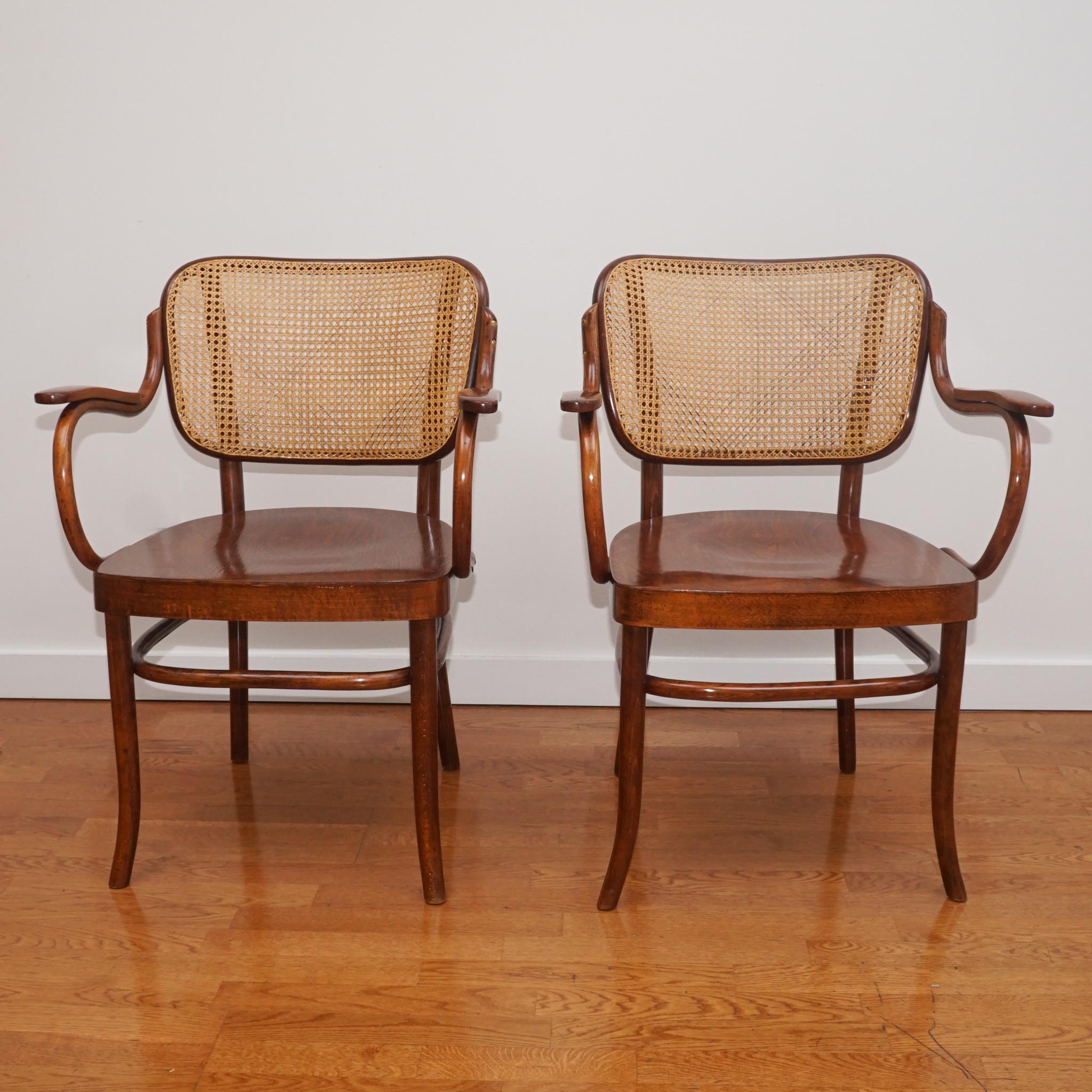 This exquisite pair of Thonet Bentwood Armchairs Model No. NR-283F. Designed in the 1930s by Gustav Adolf Schneck for Thonet-Mundus, the chairs are constructed of bent beechwood and feature cane backs and plywood seats.  Since they are both in very