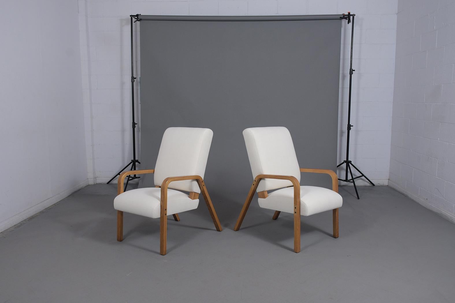 An extraordinary pair of Thonet bentwood lounge chairs are in great condition and fully restored by our team of craftsmen. The set has been professionally upholstered in a new white fabric with new foam inserts and the frames have been stained in a