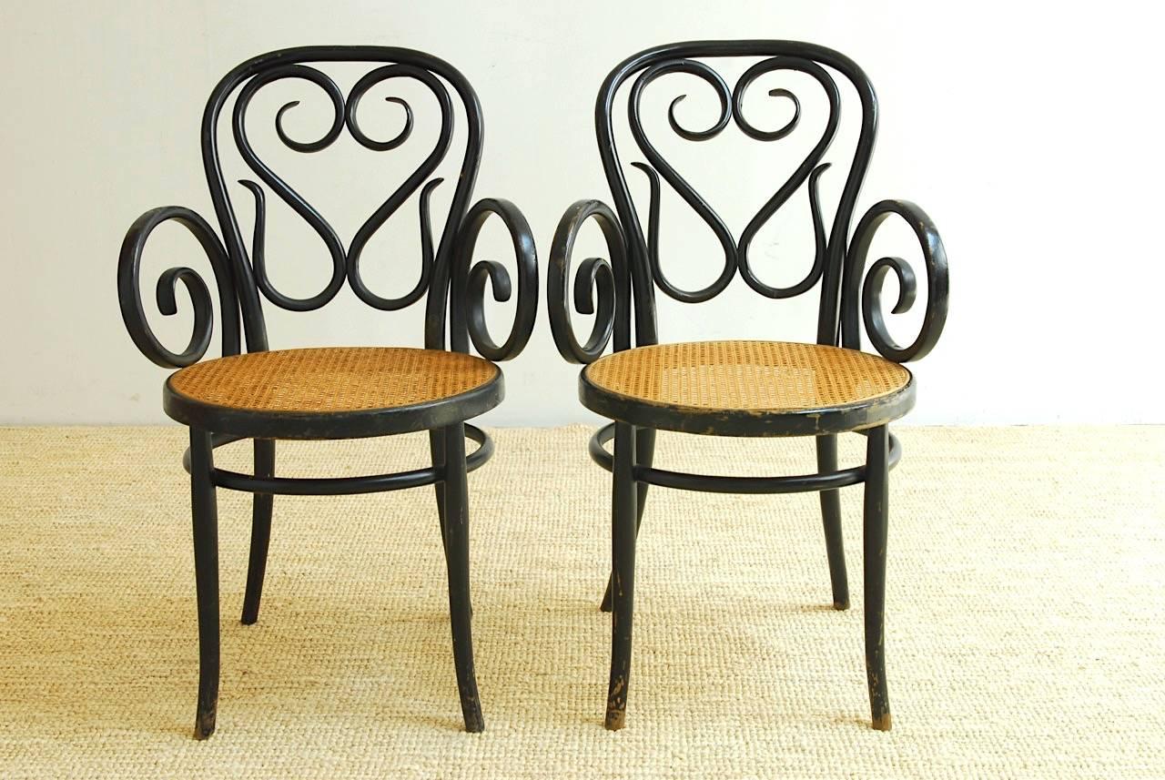 Rare pair of Michael Thonet Cafe Daum style bentwood armchairs produced by Salvatore Leone. Originally designed for the Cafe Daum in Vienna. These chairs feature a hand-caned seat and beautiful black lacquer finish. Each chair is decorated with the