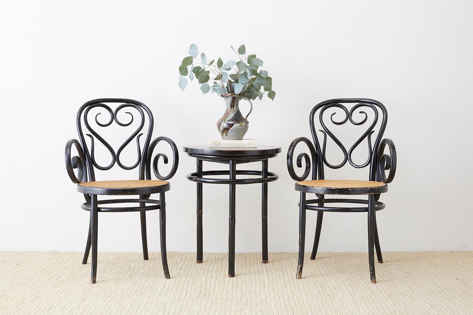 Rare pair of Michael Thonet Cafe Daum style bentwood armchairs produced by Salvatore Leone. Originally designed for the Cafe Daum in Vienna. These chairs feature a hand-caned seat and beautiful black lacquer finish. Each chair is decorated with the