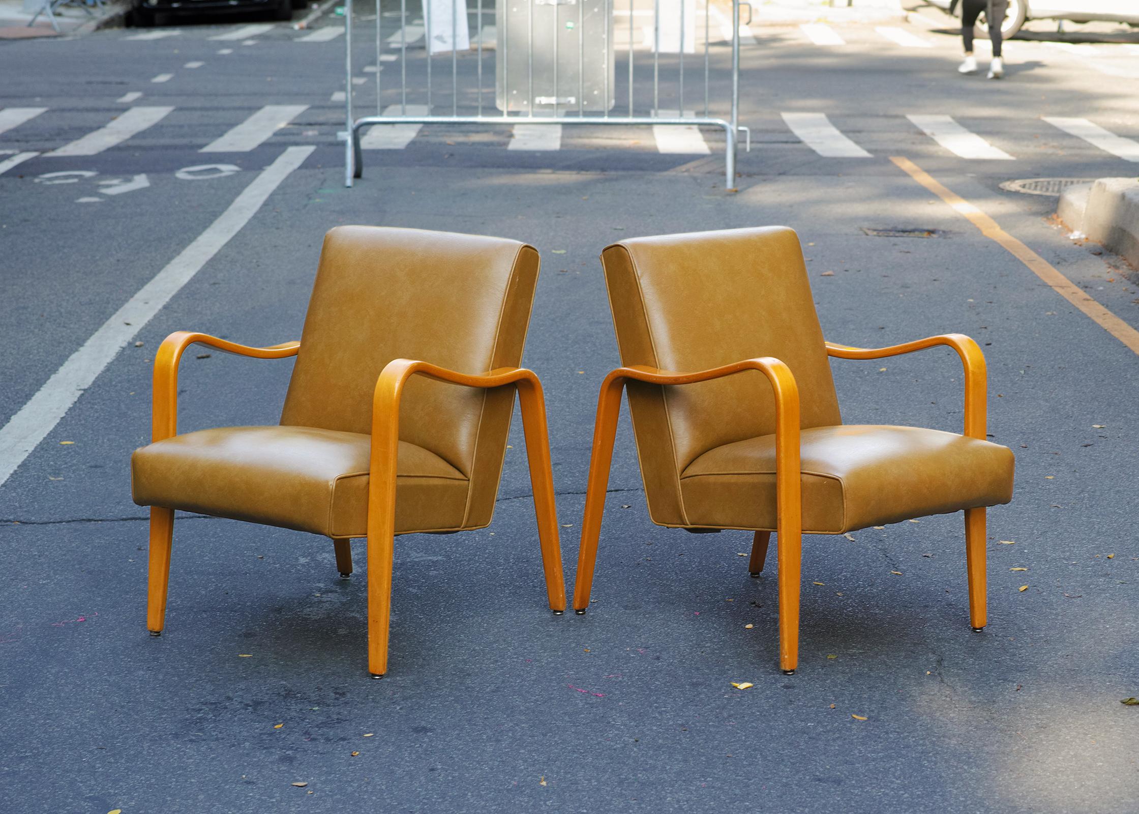 For your consideration is this pair of lounge chairs by Thonet dating from the 1960s with their original vinyl upholstery and original wood finish. The arms and legs are formed by a single piece of steam bent laminated wood that create a