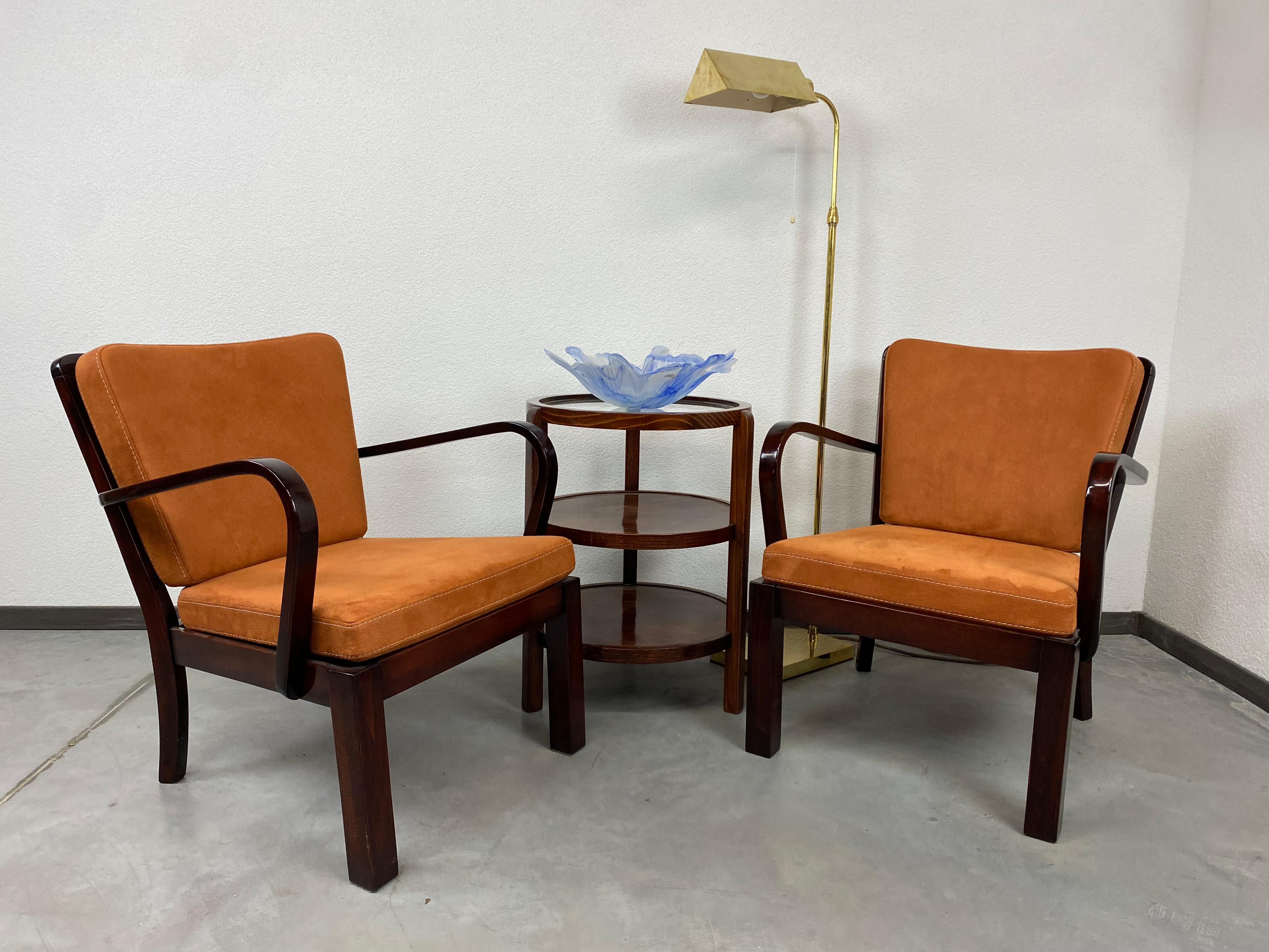 Pair of Thonet Mundus armchairs professionally stained and repolished with new terracotta fabric.
