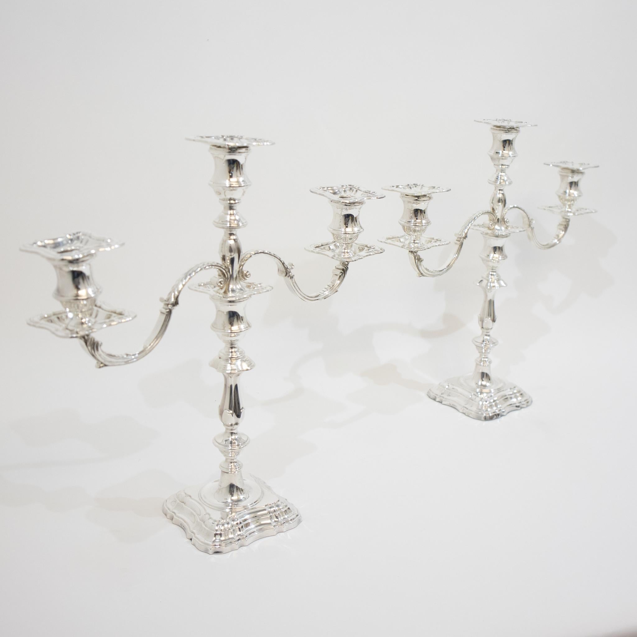A stunning pair of silver candelabra in fantastic condition. Classic in form with traditional sconces, feathered arms. The shoulder, knop and column lead down to a large graduated base. The arms detach enabling the sticks to be used separately.