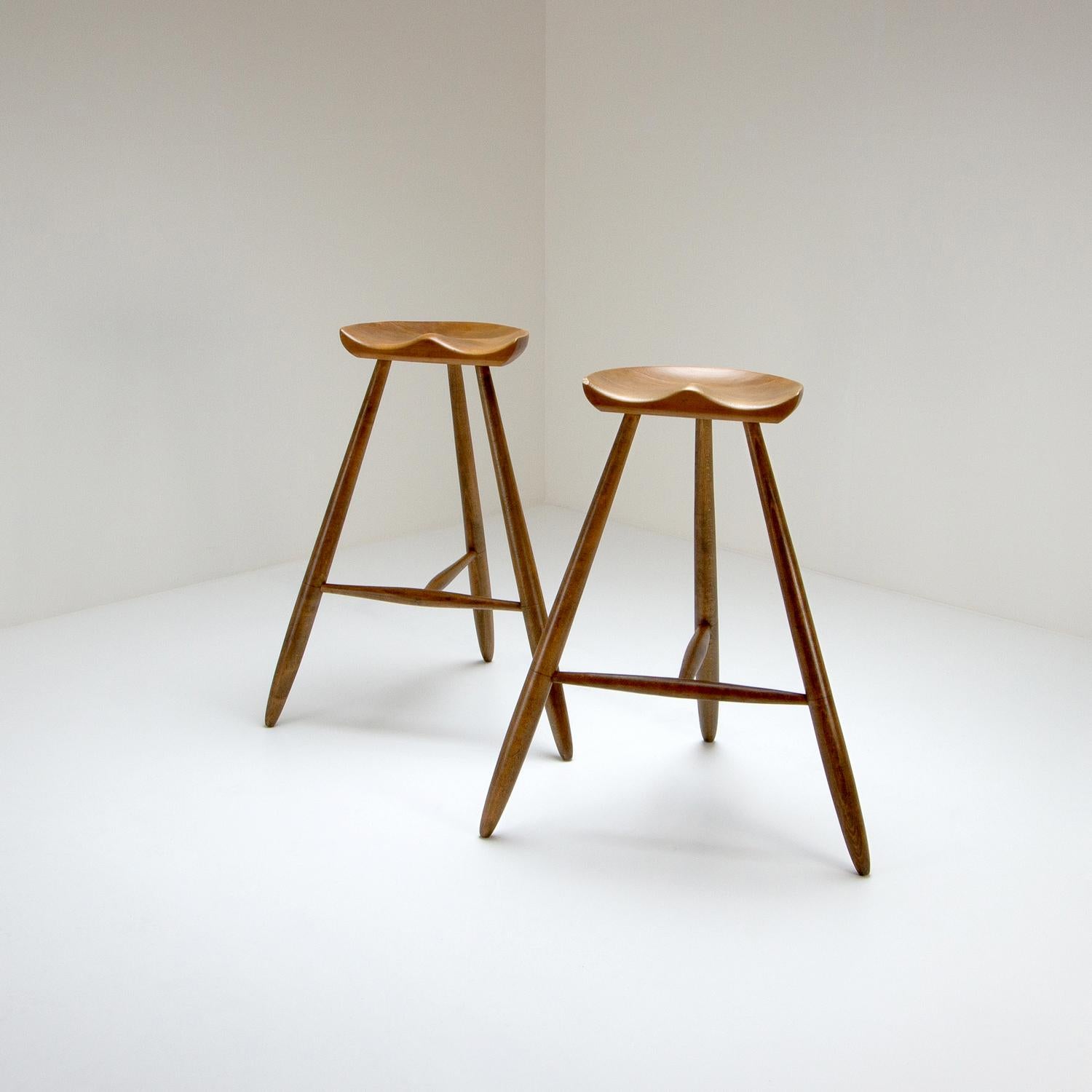 An exceptional pair of very tall functionalist three-legged milking-style stools in beech by Arne Hovmand-Olsen, Denmark, 1940s.