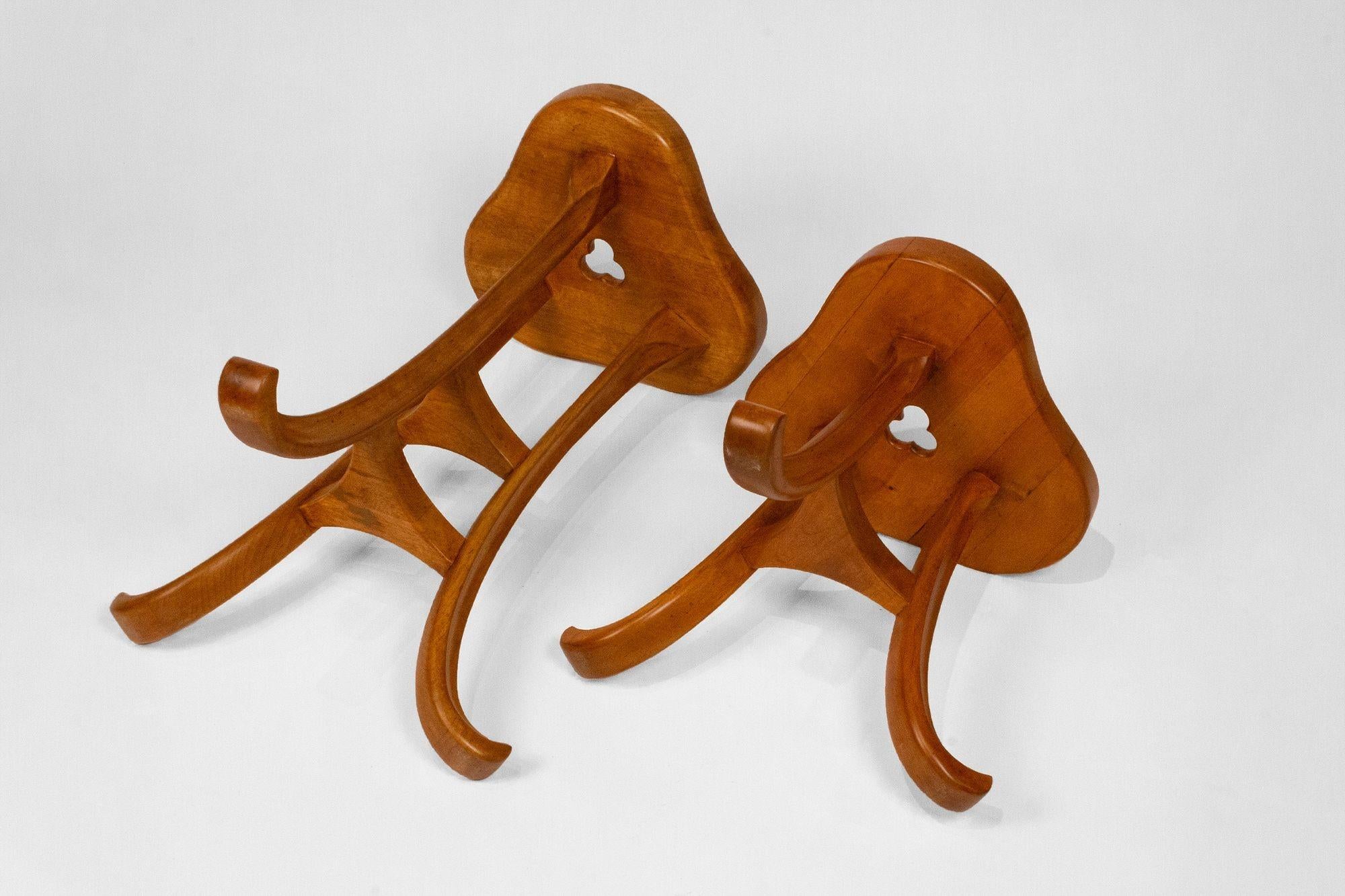 A unique pair of vintage three-legged trefoil design stools. Both stools are in very good condition with a trefoil design top mounted on three splayed legs with triangular shelves. The stools would work well in an Edward Wormley or Robsjohn Gibbings