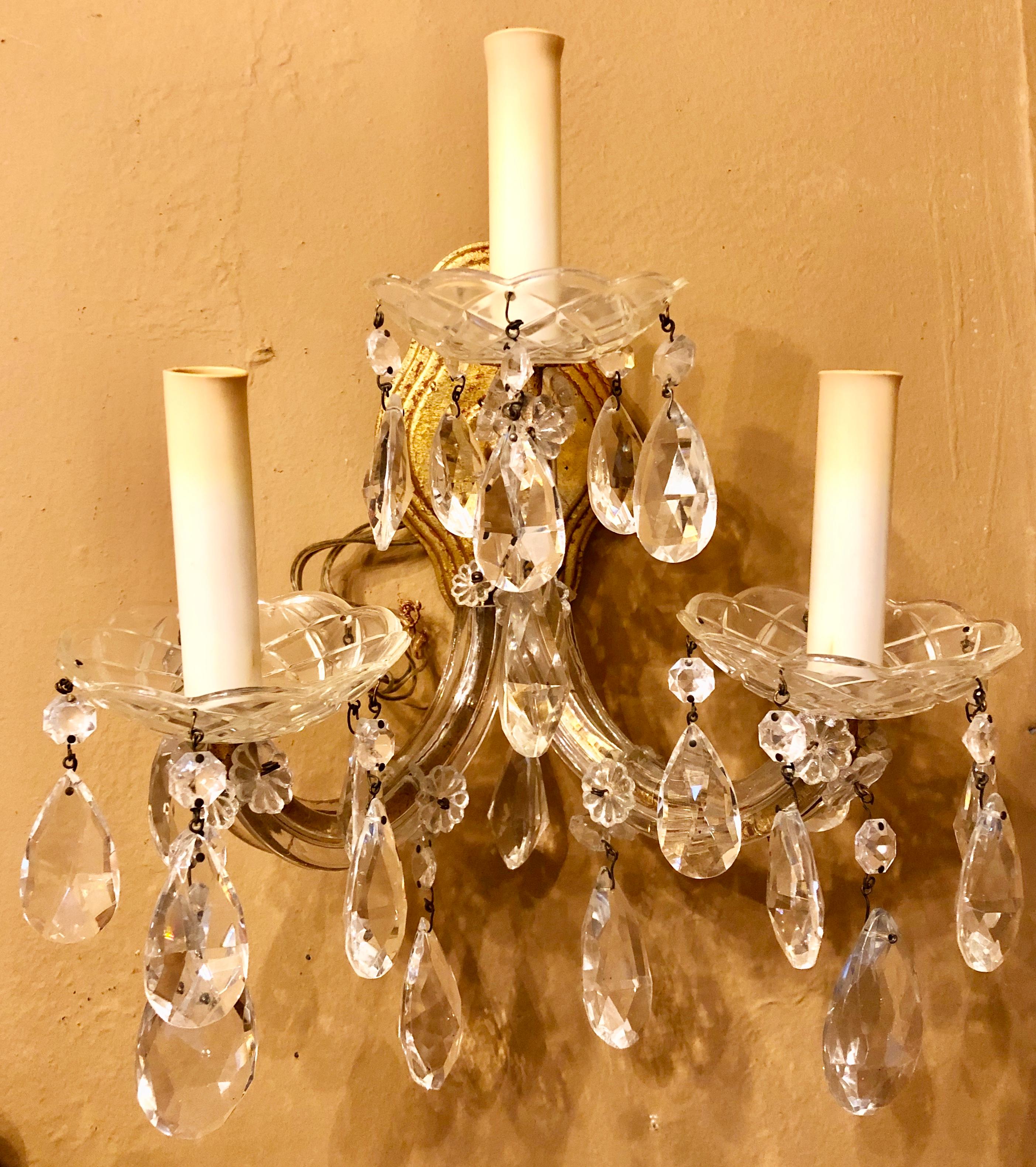 Pair of three light crystal candelabra wall sconces on giltwood. Super sweet pair of wall sconce taking three bulbs each with finely cut bobeches and hanging crystals.