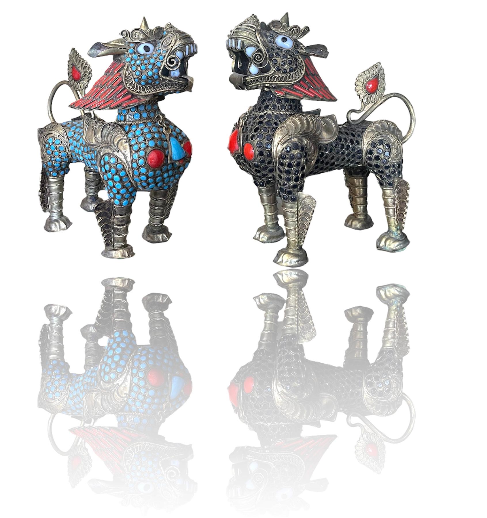 Intricately detailed pair of hand crafted metal Tibetan foo dog incense burners. Each foo has been covered in dozens of red, black and turquoise faux stones by hand. The heads are removable in order to insert incense .There is some age in patina and