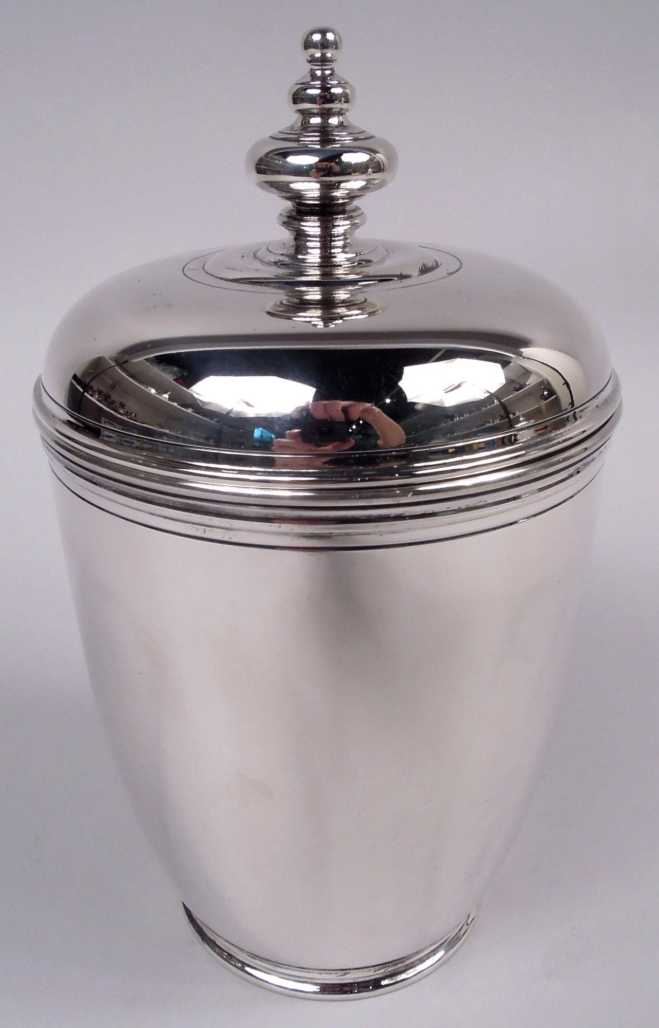 Coppia di urne classiche moderne rivestite in argento. Prodotto da Tiffany & Co. a New York, 1914 circa. Ciotola curva e affusolata con orlo a bocca ribattuto e piede corto a gradini. Coperchio a cupola; terminale a doppio pomolo con perline.