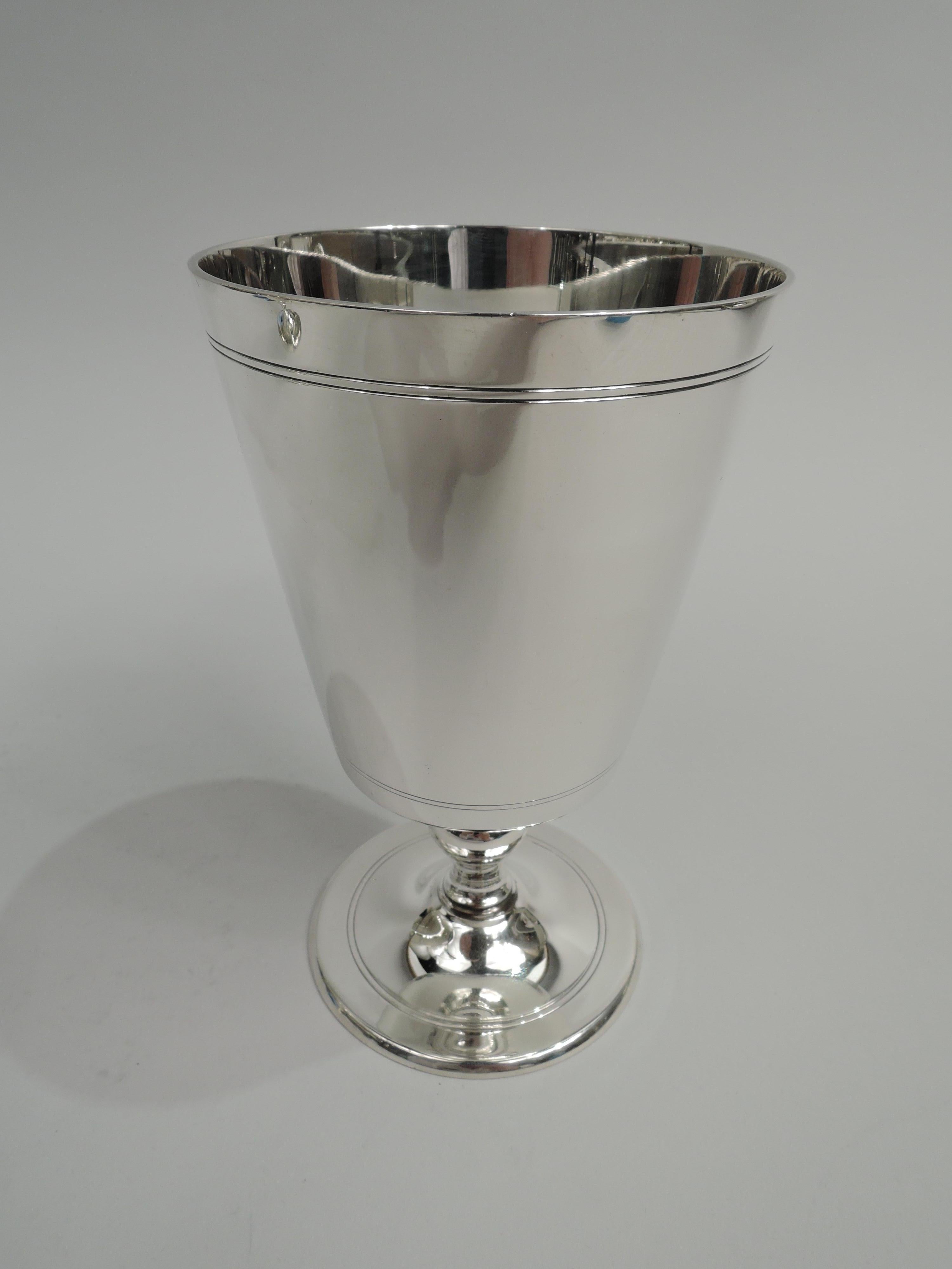 Pair of Art Deco sterling silver goblets. Made by Tiffany & Co. in New York, ca 1923. Each: Straight and tapering bowl with curved bottom, baluter support, and gently raised foot. Spare Modern form with incised bands. Perfect for twosome tippling.
