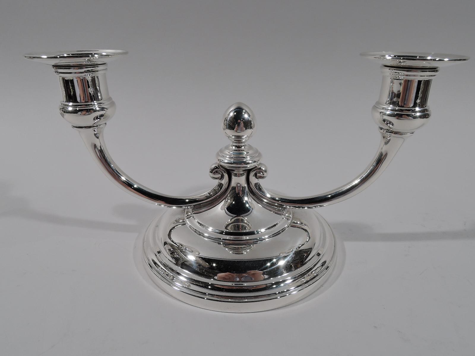Pair of Art Deco sterling silver 2-light candelabra. Made by Tiffany & Co. in New York, ca 1928. Each: Large round and domed base with raised center terminating in acorn finial. Two low-slung c-scroll branches, each terminating in single bellied