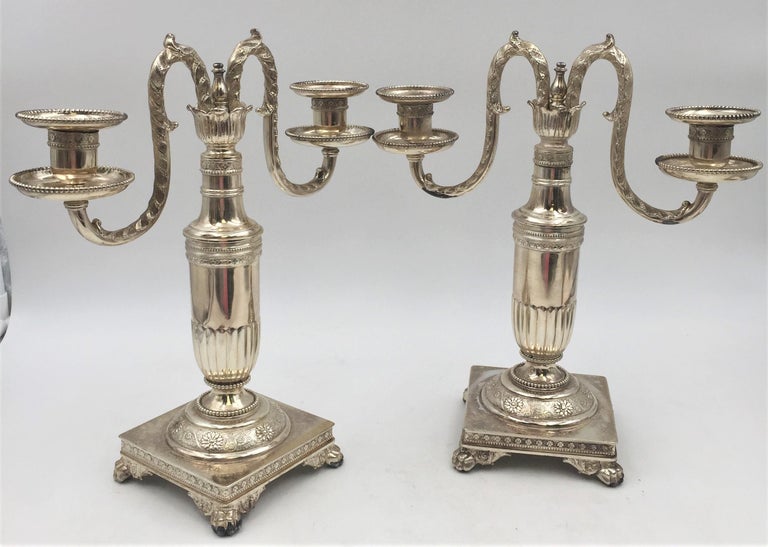 Pair of Tiffany & Co. silver soldered candelabras in pattern 4663 from 1877 standing on 4 claw-shaped feet, with floral decorations, beaded rims, and other decorative motifs. Each measures 12 1/4'' in height by 10 3/4'' from holder to holder and the
