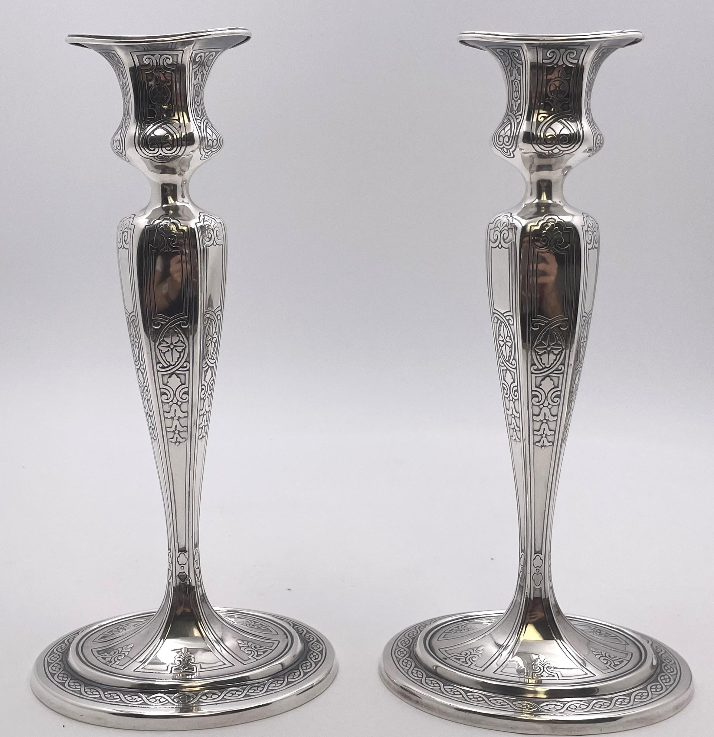 Pair of Tiffany & Co. sterling silver candlesticks, beautifully engraved with floral and geometric motifs on the body and base and in pattern number 17659A from 1910. They measure 9 1/4'' in height by 4 1/2'' in depth at the base, are weighted, and