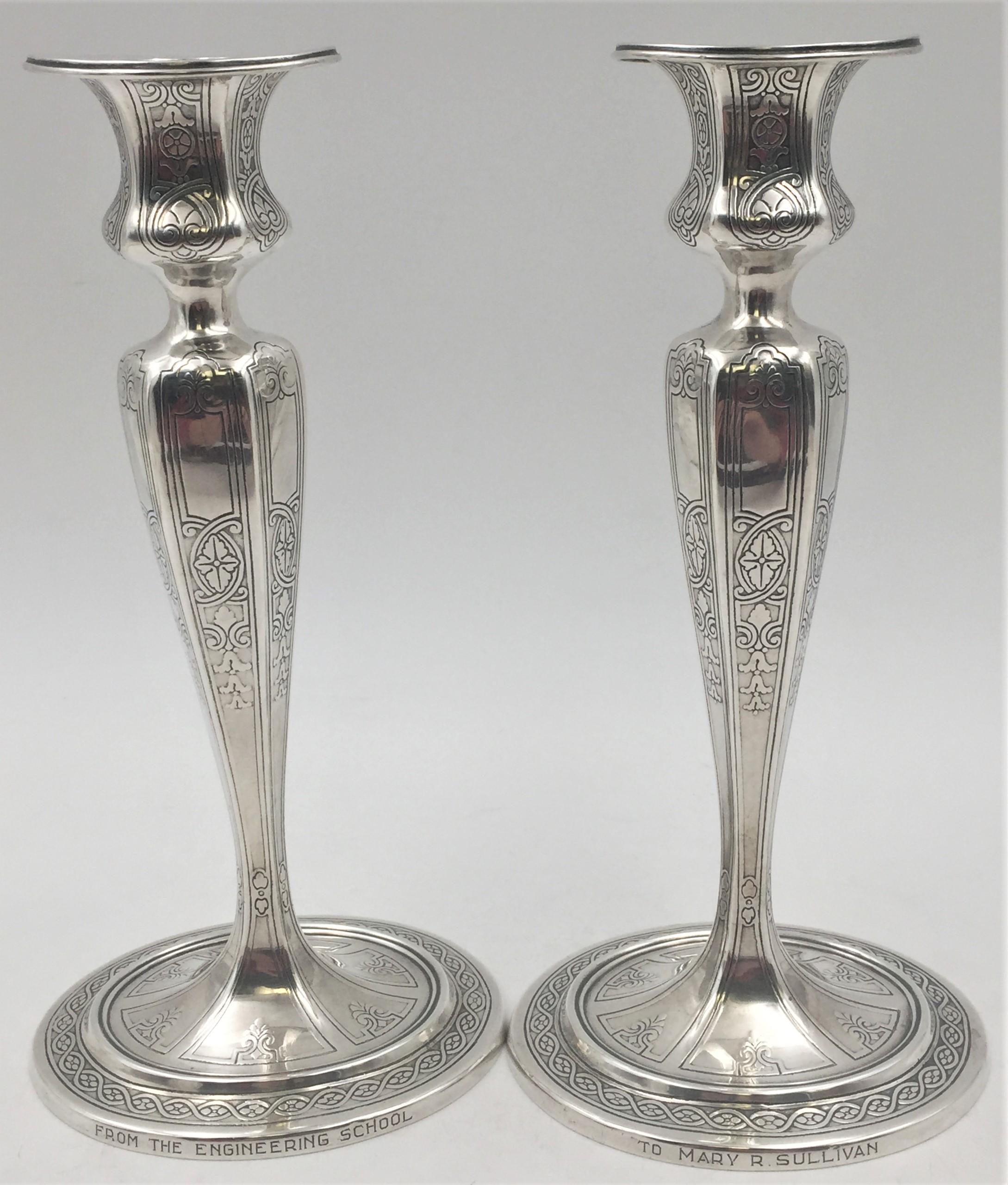 Pair of Tiffany & Co. sterling silver 1910 candlesticks in Art Deco style with engraved floral and stylized geometric motifs from 1910 in pattern number 17659A. Each measures 9 1/2'' in height by 4 1/2'' in base length and bears hallmarks as shown.