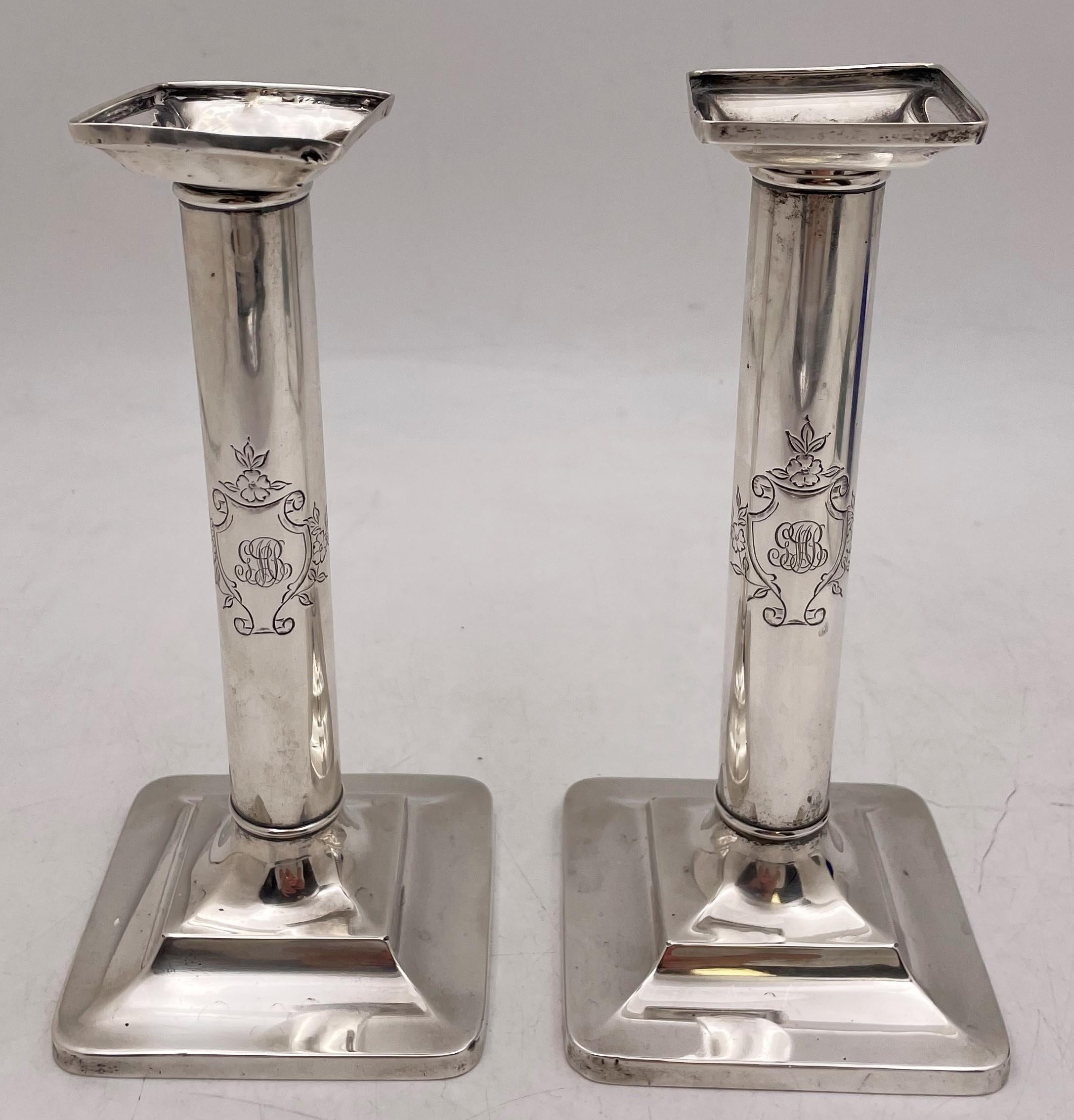 Pair of Tiffany & Co. sterling silver candlesticks in pattern 15893 from 1903, with bobeches, showcasing floral cartouches and a monogram, measuring 8'' in height by 3 3/4'' in depth (square base) and bearing hallmarks as shown. Sold 